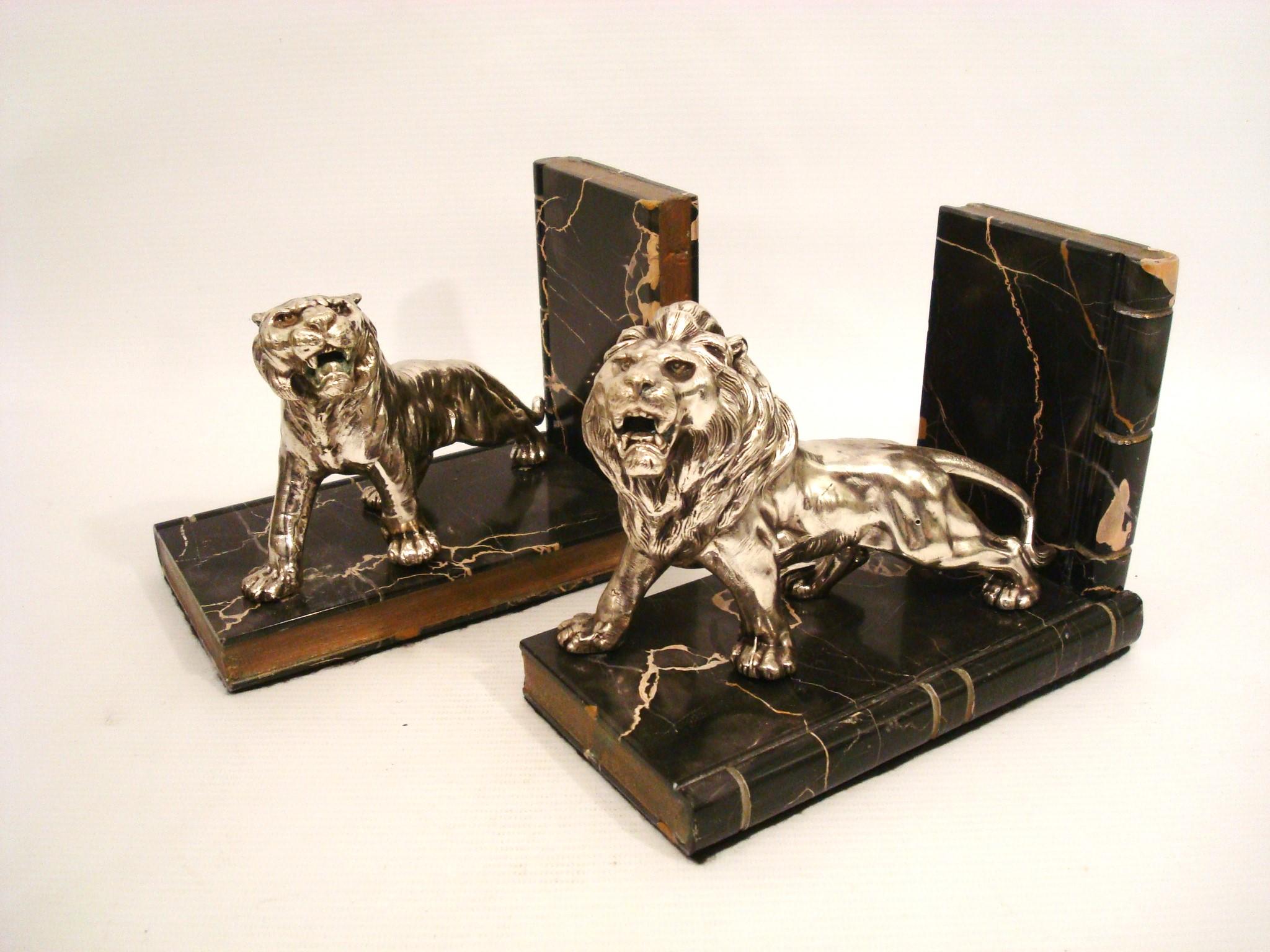 Coppia di fermalibri francesi con leone e tigre
Una coppia di fermalibri. Ogni fermalibri presenta una scultura metallica di un grande felino, uno dei quali è un leone e l'altro una tigre. Le sculture sono montate su una base che ricorda il marmo