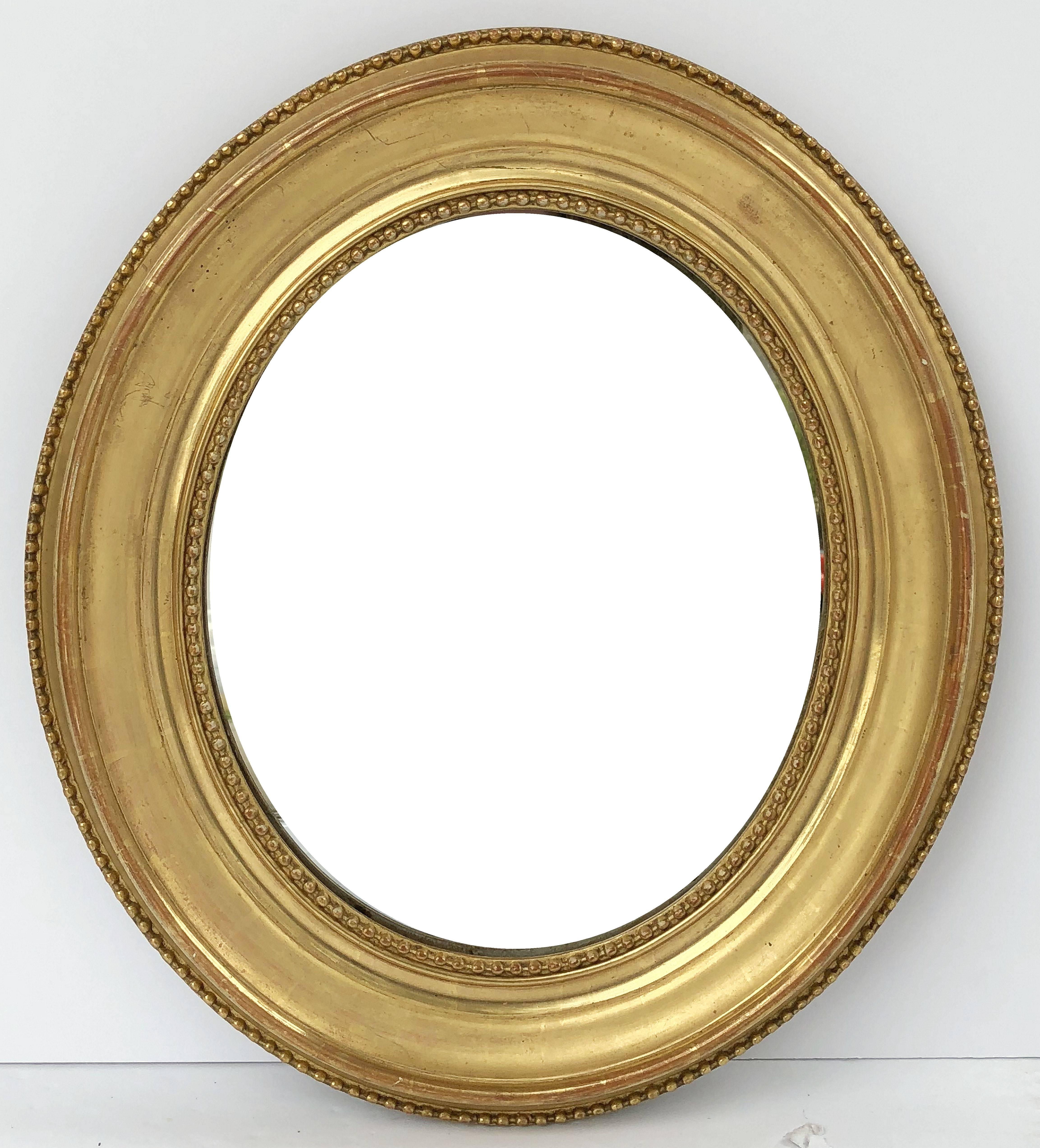 A fine pair of Louis Philippe oval framed gilt mirrors from France, each mirror featuring a beaded gilt moulding around an oval glass.

Dimensions are H 17 1/4 inches x W 15 inches 

Two available - Individually priced - $1295 each mirror.
  