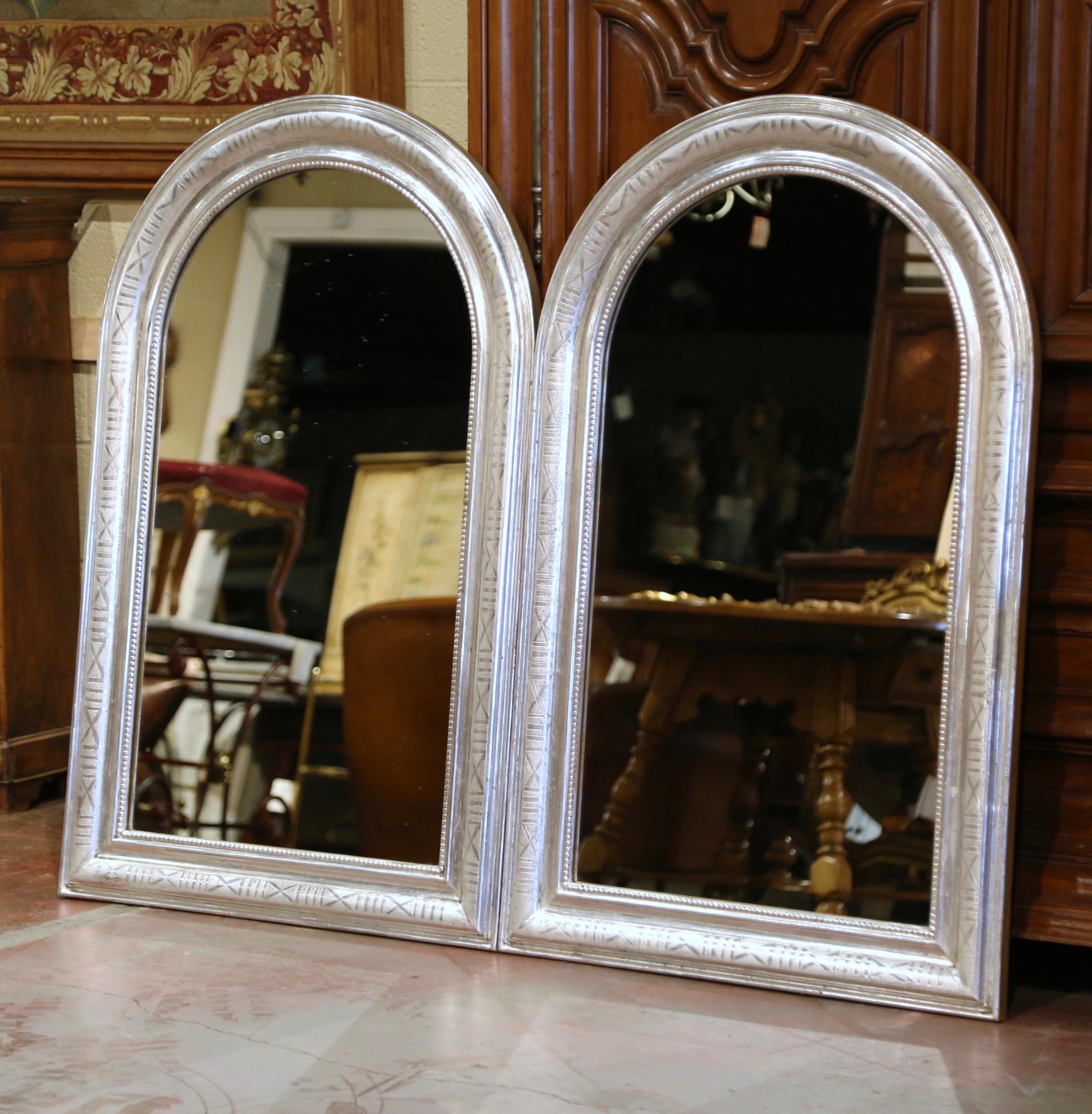 Decorate a master bathroom with this elegant pair of wall mirrors! Crafted in France, circa 1970 and four feet tall, each antique mirror has traditional, timeless lines with an elegant arched top. The frame is decorated with a luxurious silver leaf