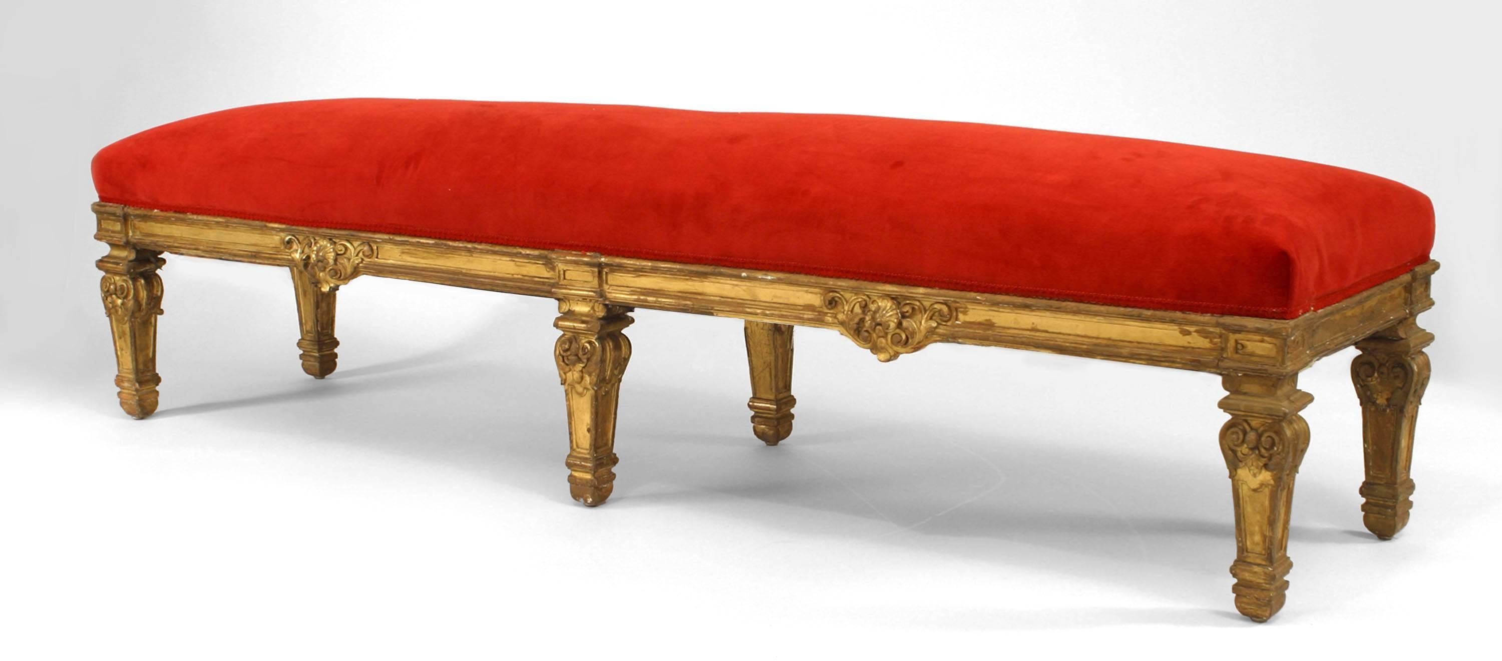 Paire de bancs en bois sculpté et doré de style Louis XIV (19ème siècle) à 6 pieds et assise tapissée de velours rouge.
