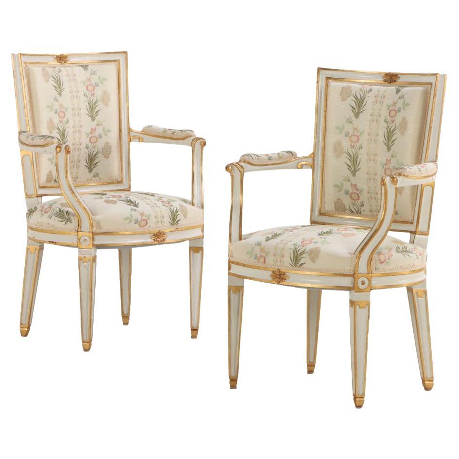 Pair of French Louis XIV style painted and gilt open arm chairs, C 1990.