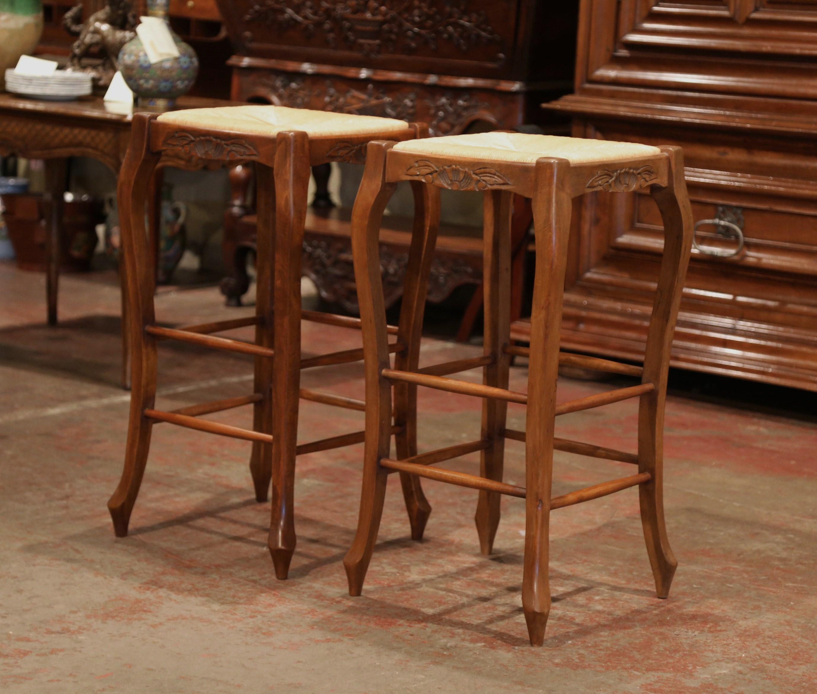 Place these bar stools around a kitchen island, crafted in France, the Classic, French stools are 30” in height; they feature a rush seat, four cabriole legs and are embellished with a carved shell motif with foliage decor under the seat. These