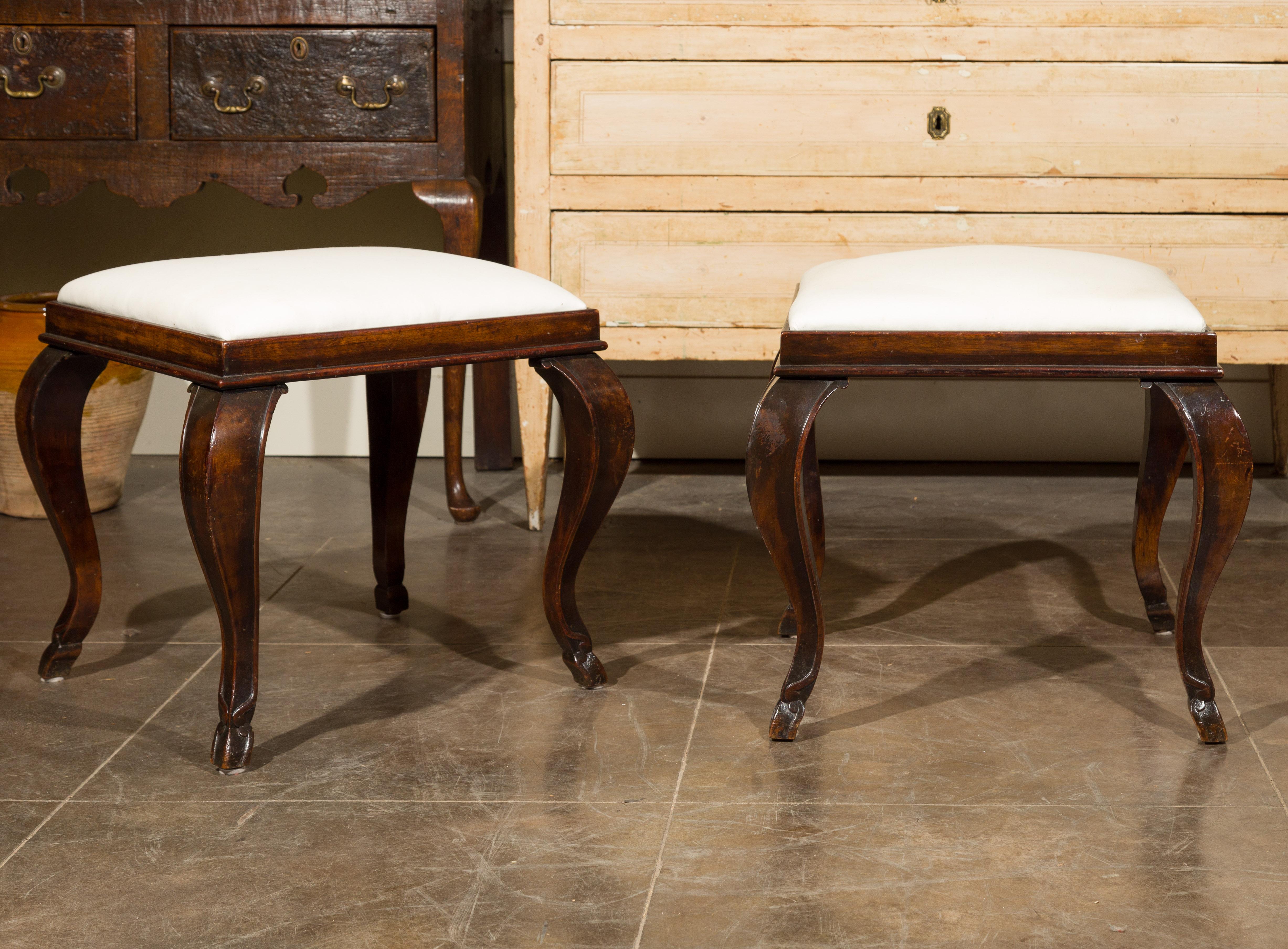 A pair of French Louis XV style wooden stools from the late 19th century, with cabriole legs and new muslin upholstery. Born in France at the end of Emperor Napoleon III's reign, each of this pair of wooden stools presents the stylistic