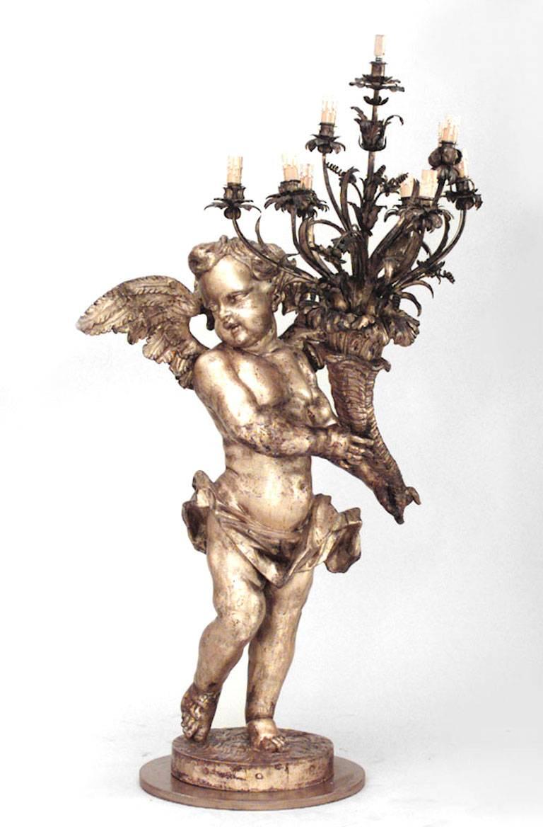 Pair of French Louis XV style (19th Century) gilt cupid torchiere with wings holding cornucopia candelabra (PRICED AS Pair).
