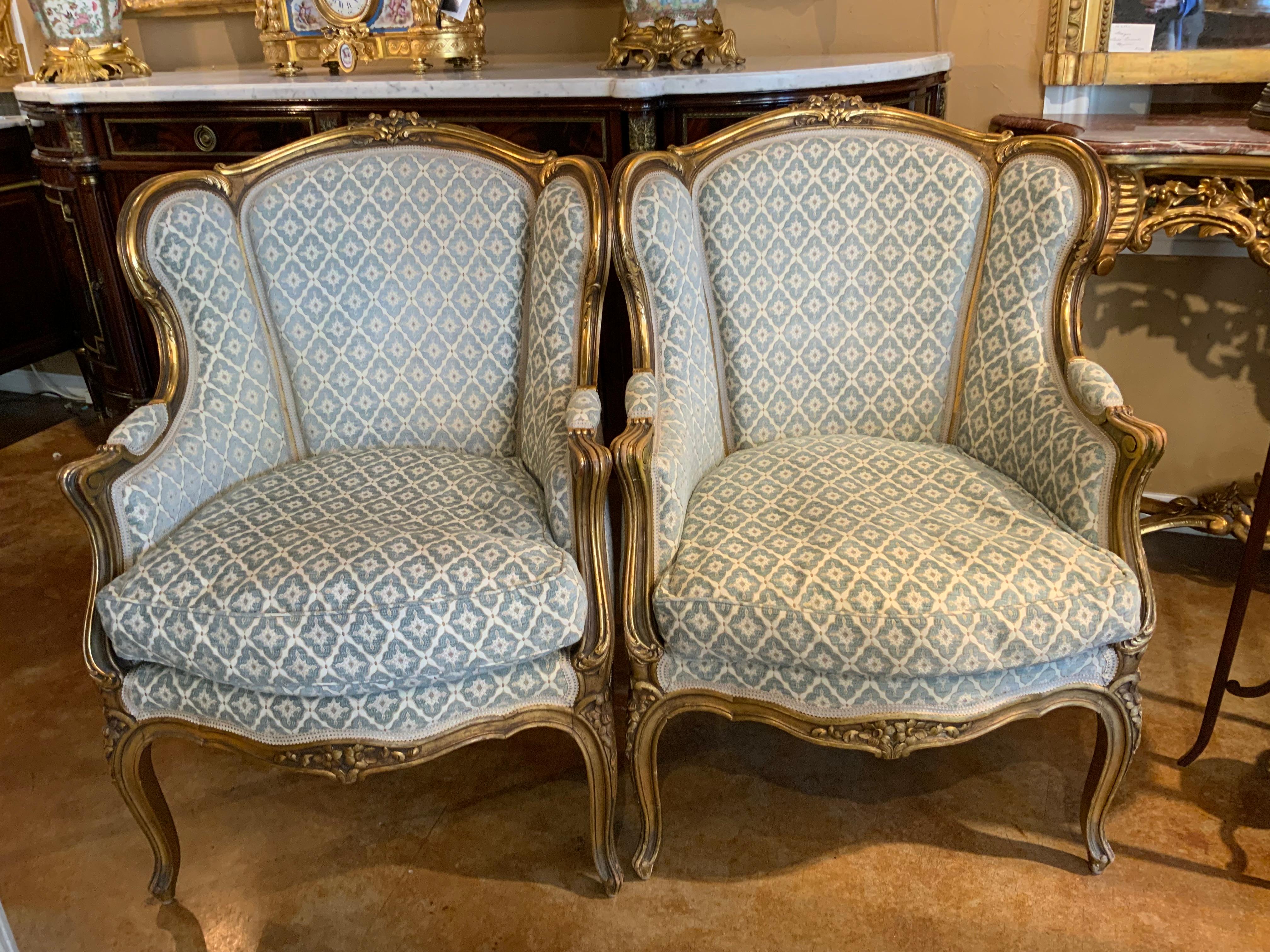 Louis XV Style Giltwood chairs with original gilding
In the curved bergere style. The fabric is a designer 
Fabric in great condition in pale blue hue. The crest of the
Chairs has a lovely carved floral motif.