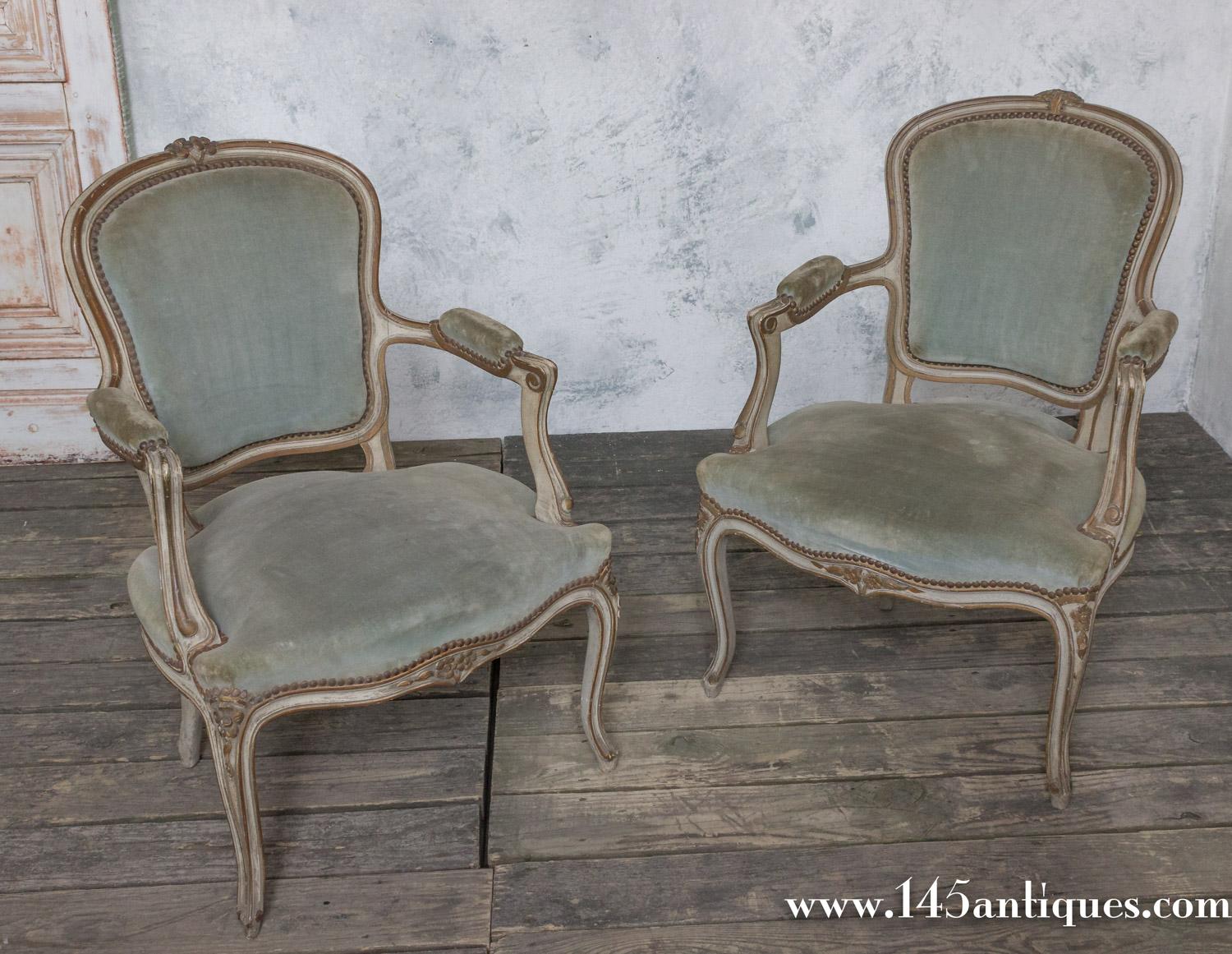 An exquisite pair of Louis XV style armchairs in sage green. Crafted with loving care in France during the early 20th century, this gorgeous pair of chairs exude an effortless grace. Finished with a hand patinated frame in creamy bluish grey, they