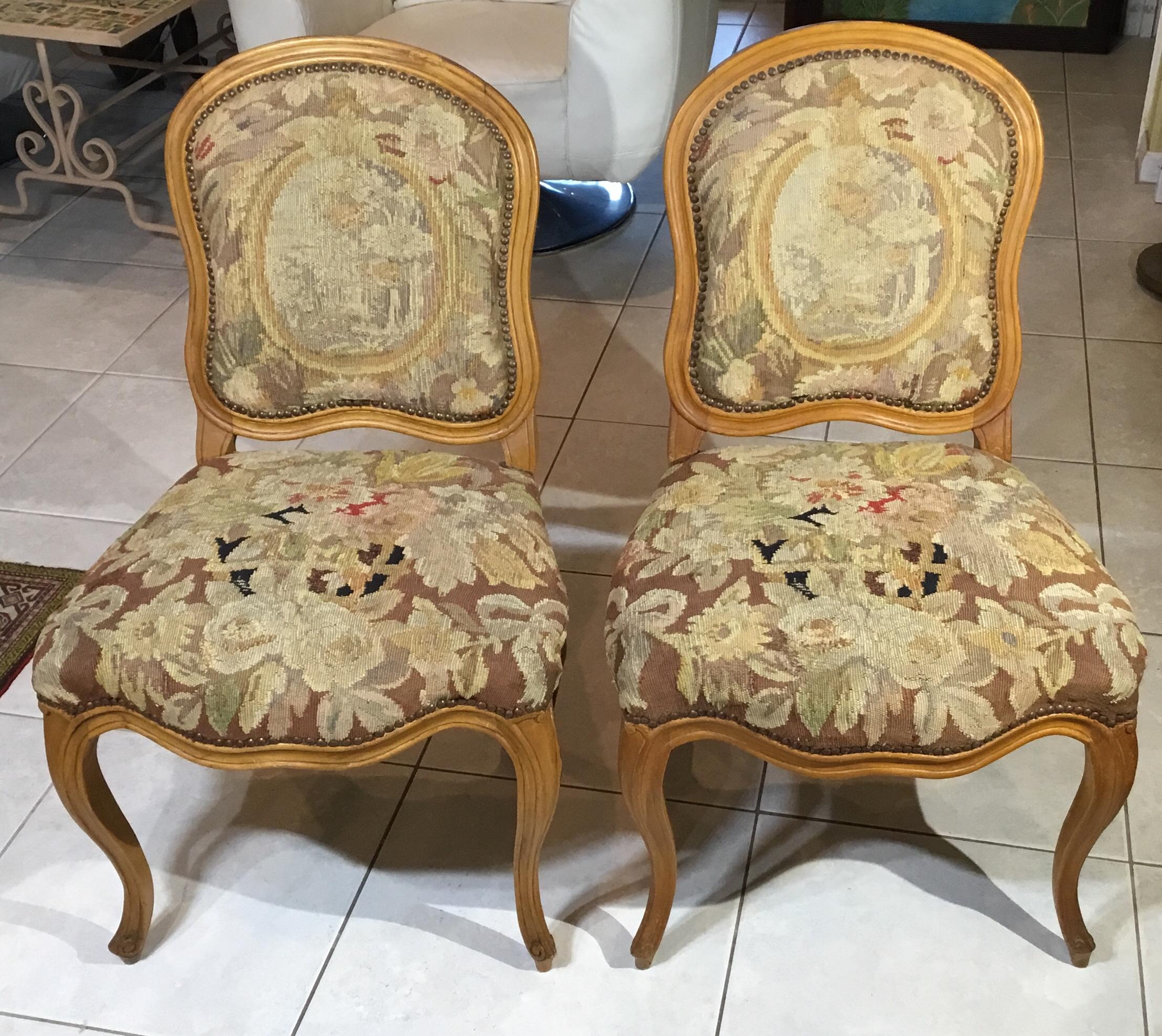 Elagent hand carved pair of chairs as early as 1930s ,with the original upholstery of antique Aubusson handwoven tapestry. Tapestry in both chairs has some repairs due to use and time ,and one small repair it the wood in one chair ,also some minor