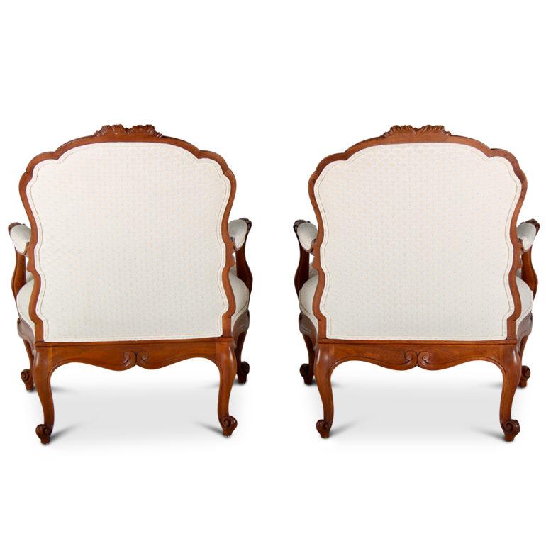 A pair of finely-carved and recently-upholstered French bergeres in walnut, circa 1900.

 