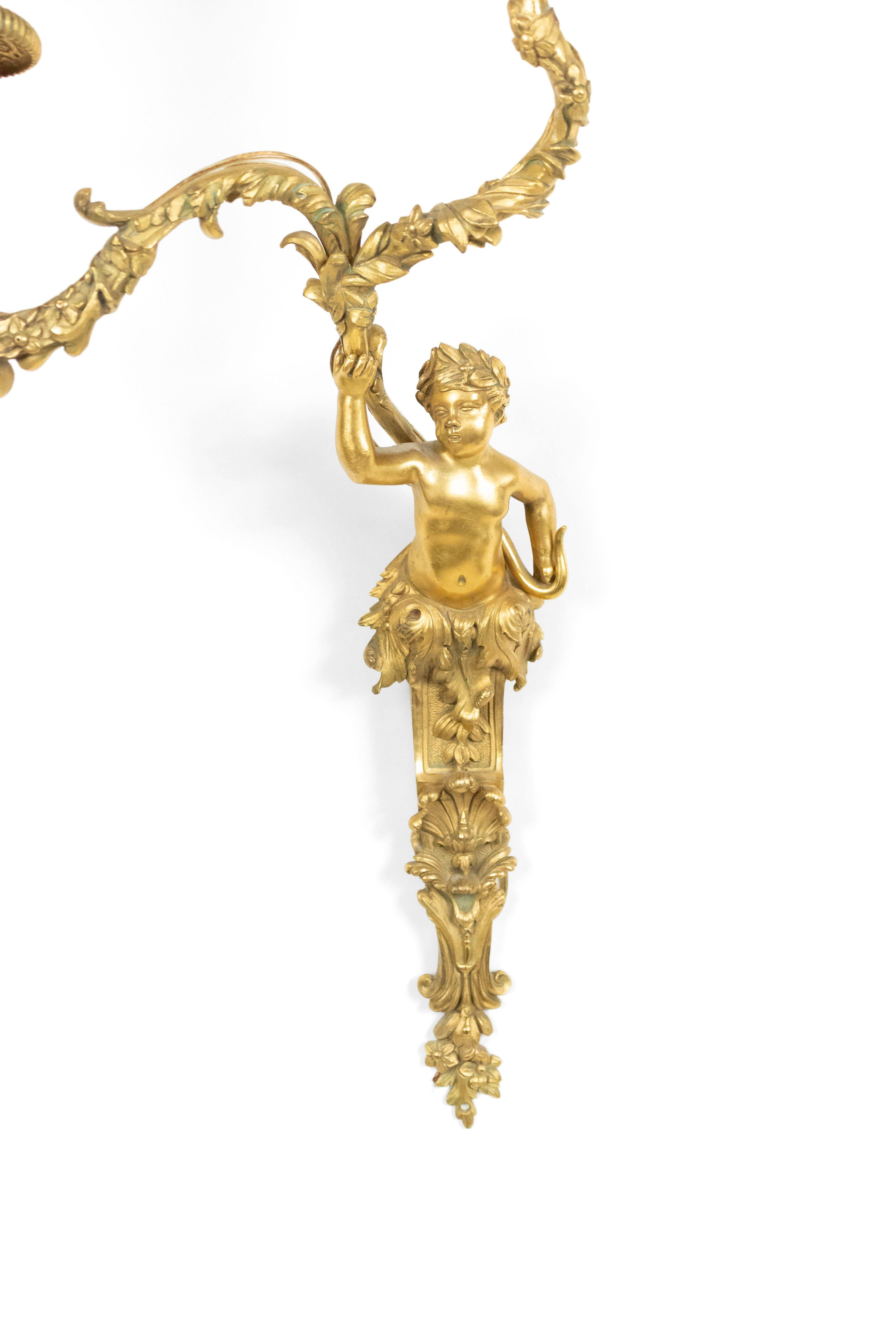 Pair of French Louis XV-style (20th Century) bronze dore wall sconces with two foliage-decorated arms supported by a cherub figure. (PRICED AS PAIR).
 
