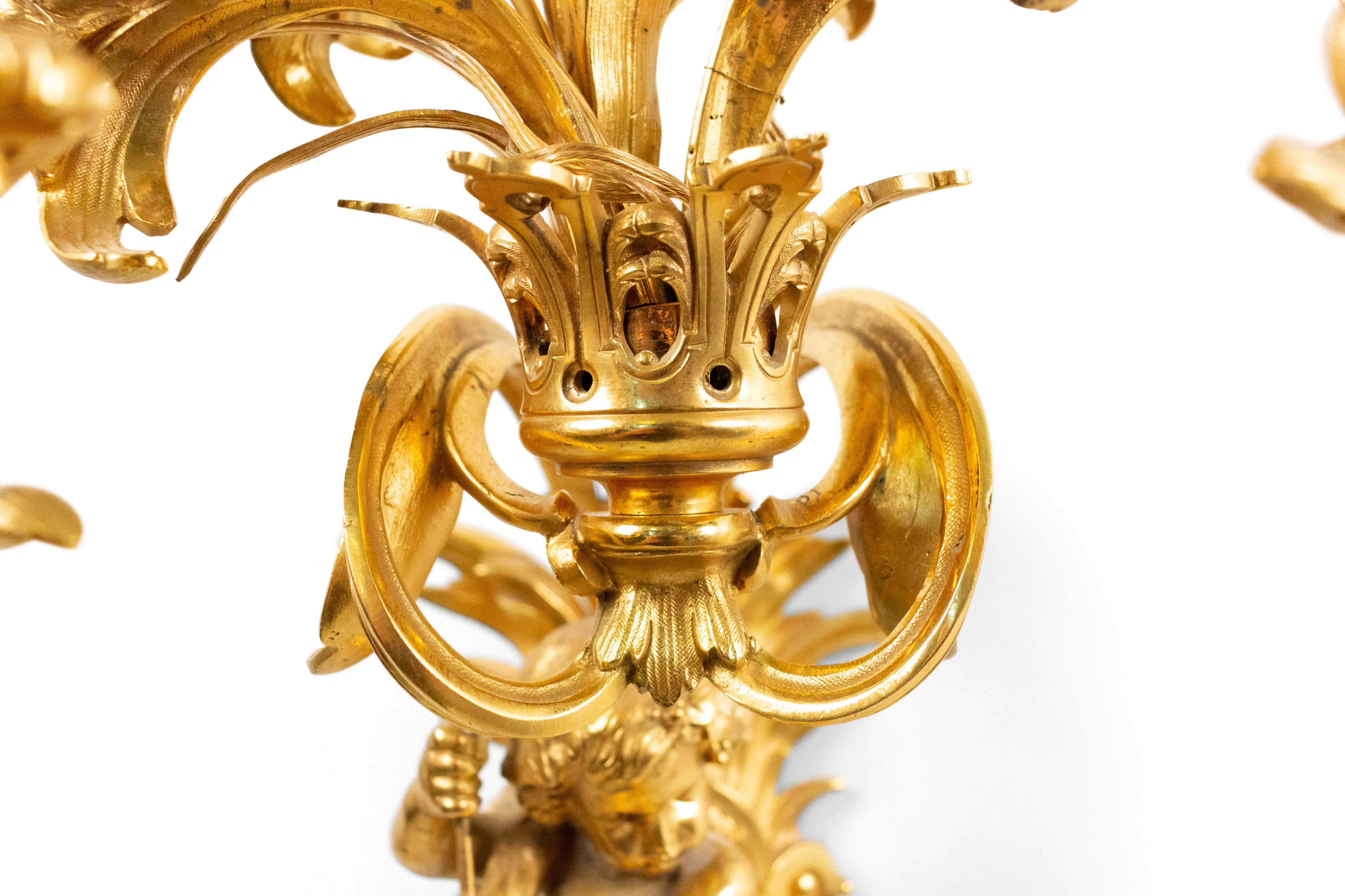 Pair of French Louis XV style bronze doré wall sconce with five arms and cupid holding musical instruments with floral trim (19th century).
 
