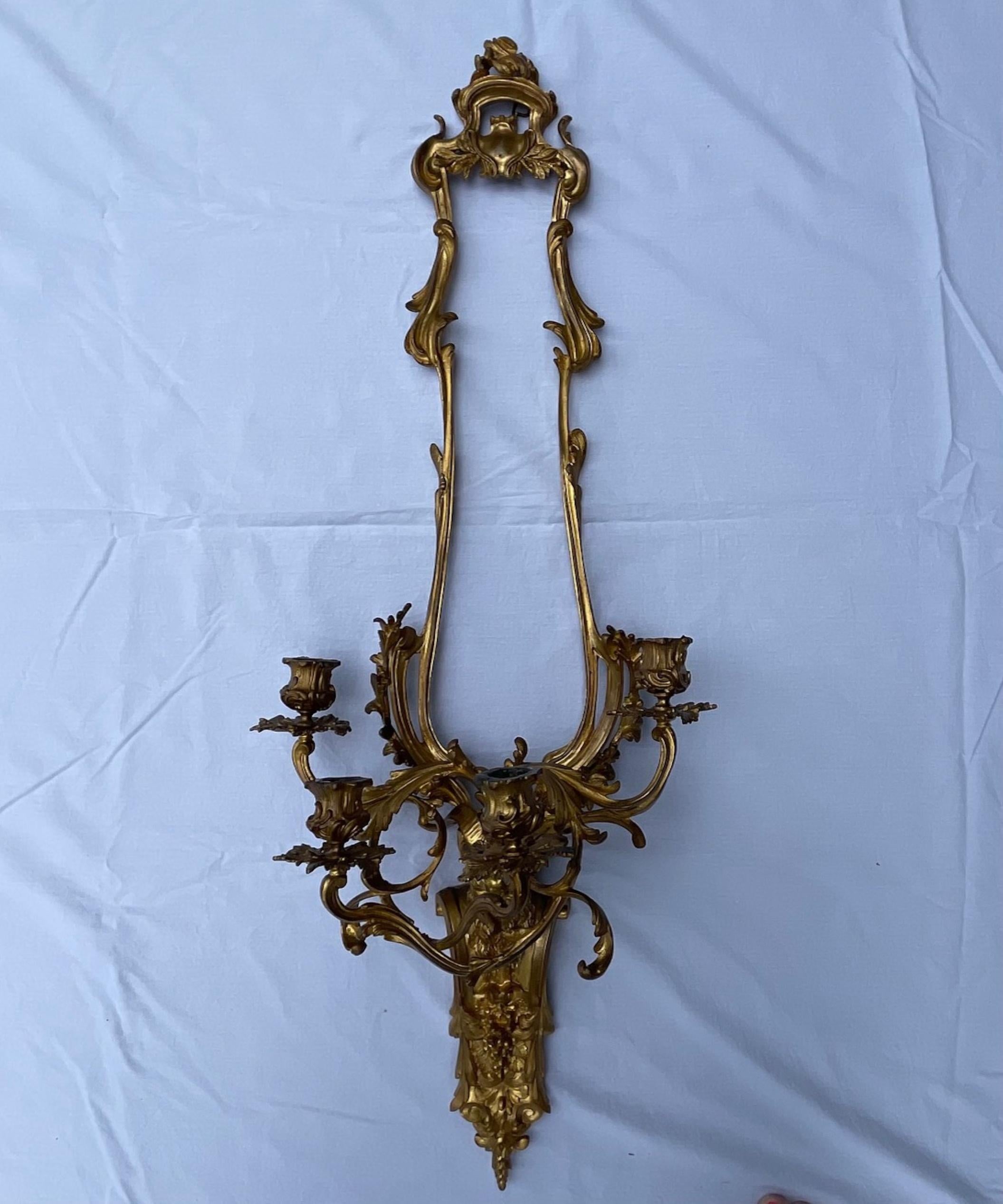 Pair of French Louis XV style bronze four light sconces

Important antique pair of fire gilded bronze wall sconces. They are unusual and of exceptional quality. This rare model with finely casted and chiseled bronze focuses on foliage and acanthus