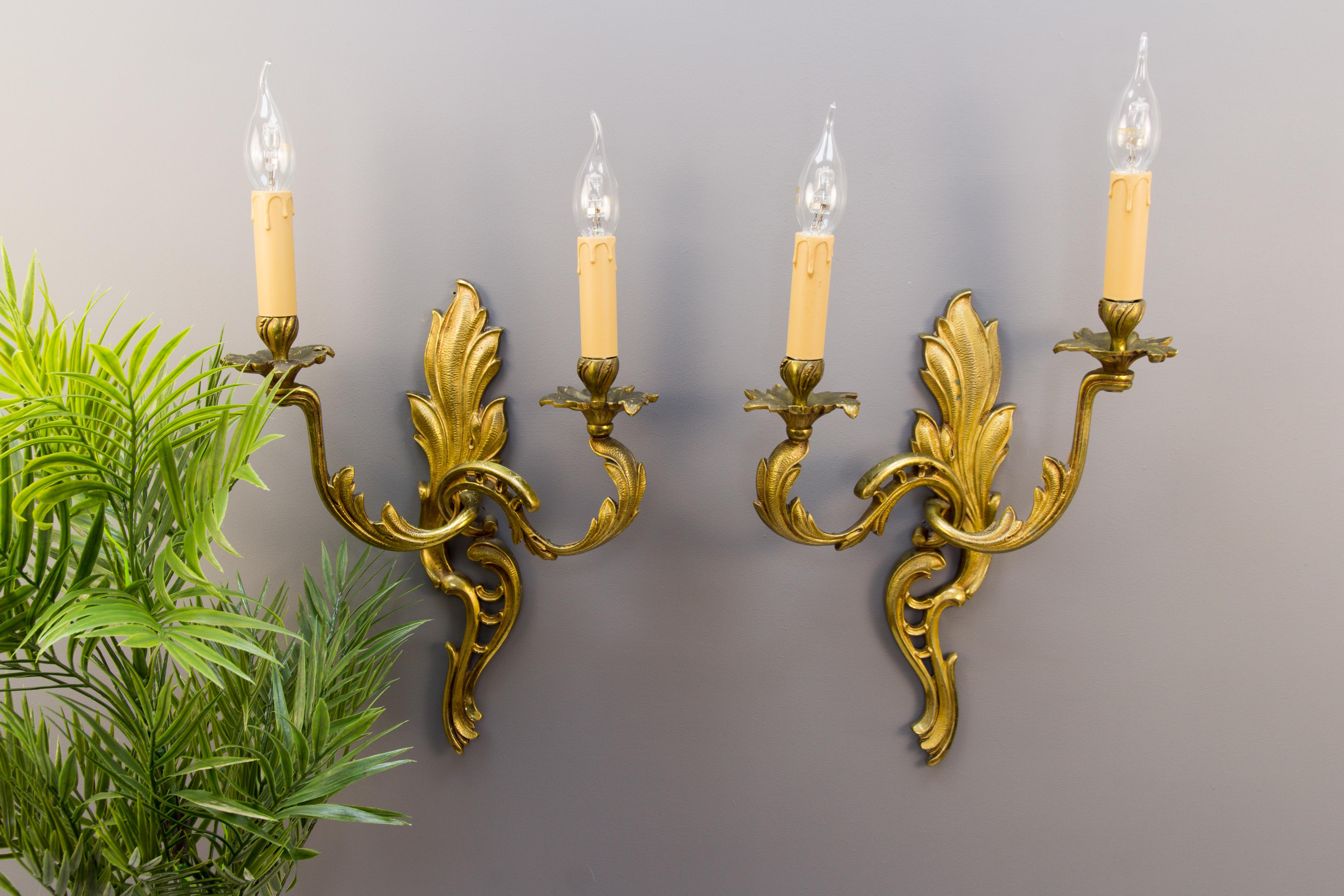 Pair of Louis XV French Rococo style two-arm sconces. Curvy asymmetrical acanthus leaf-like bronze scrolls in Classic French Rococo style. Each arm has sockets for E14 size light bulbs, France, circa the 1930s.
Dimensions (each sconce without light
