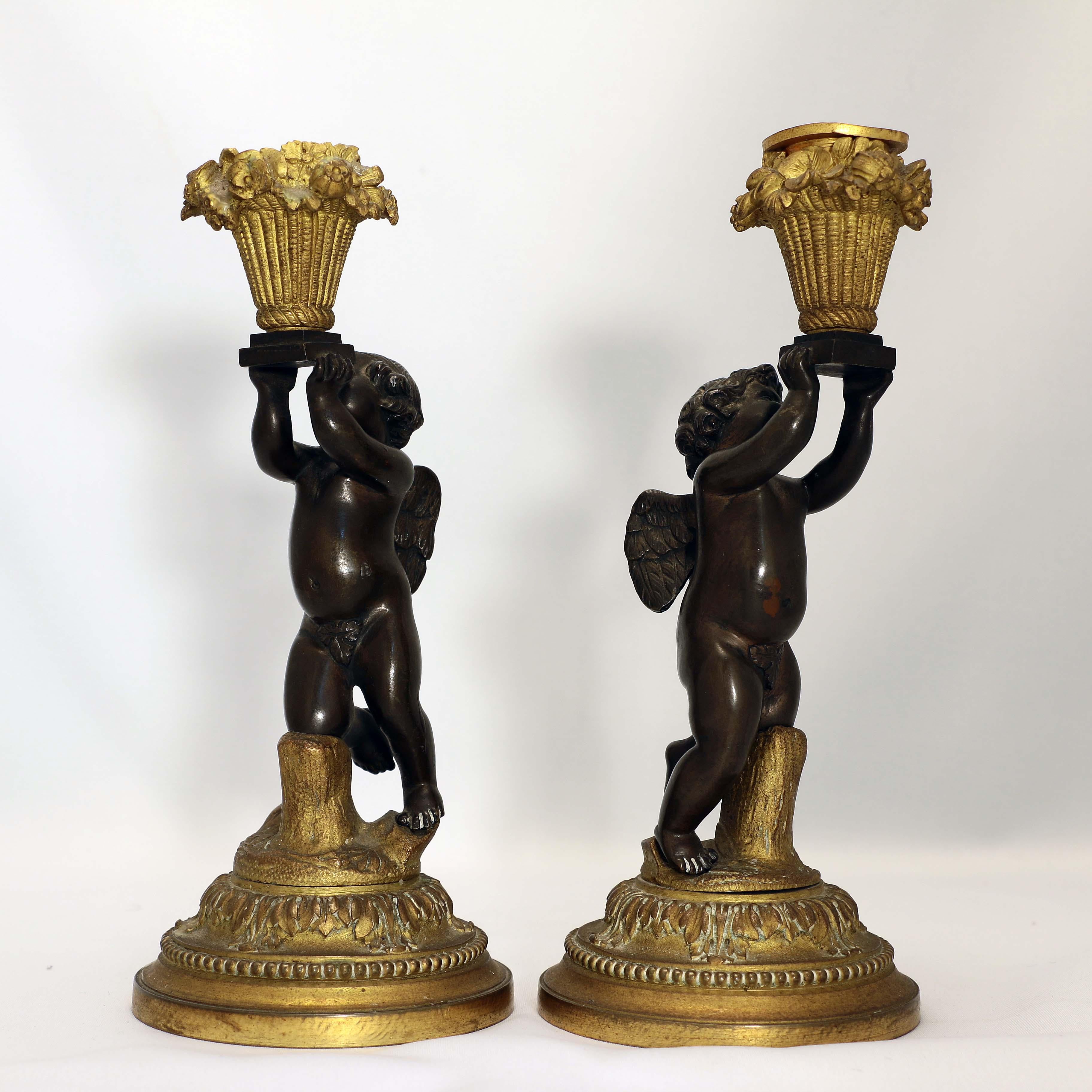 This charming pair speak of service, love and the bounty of the earth. Each cherub, on one knee, holds aloft a brimming panier with fruit and flowers, each is raised on a beaded circular foot.