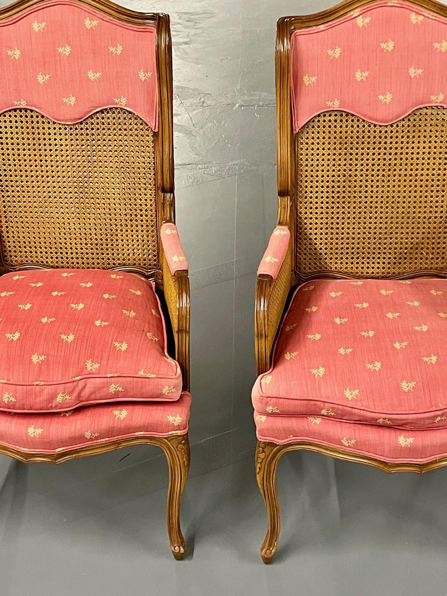 Pair of French Louis XV style cane occasional/armchairs, wingbacks, France, 1960s.

This finely carved pair of double cane back and cane arm chairs are indicative of the period having high style and design. Each in their Original fabric which is