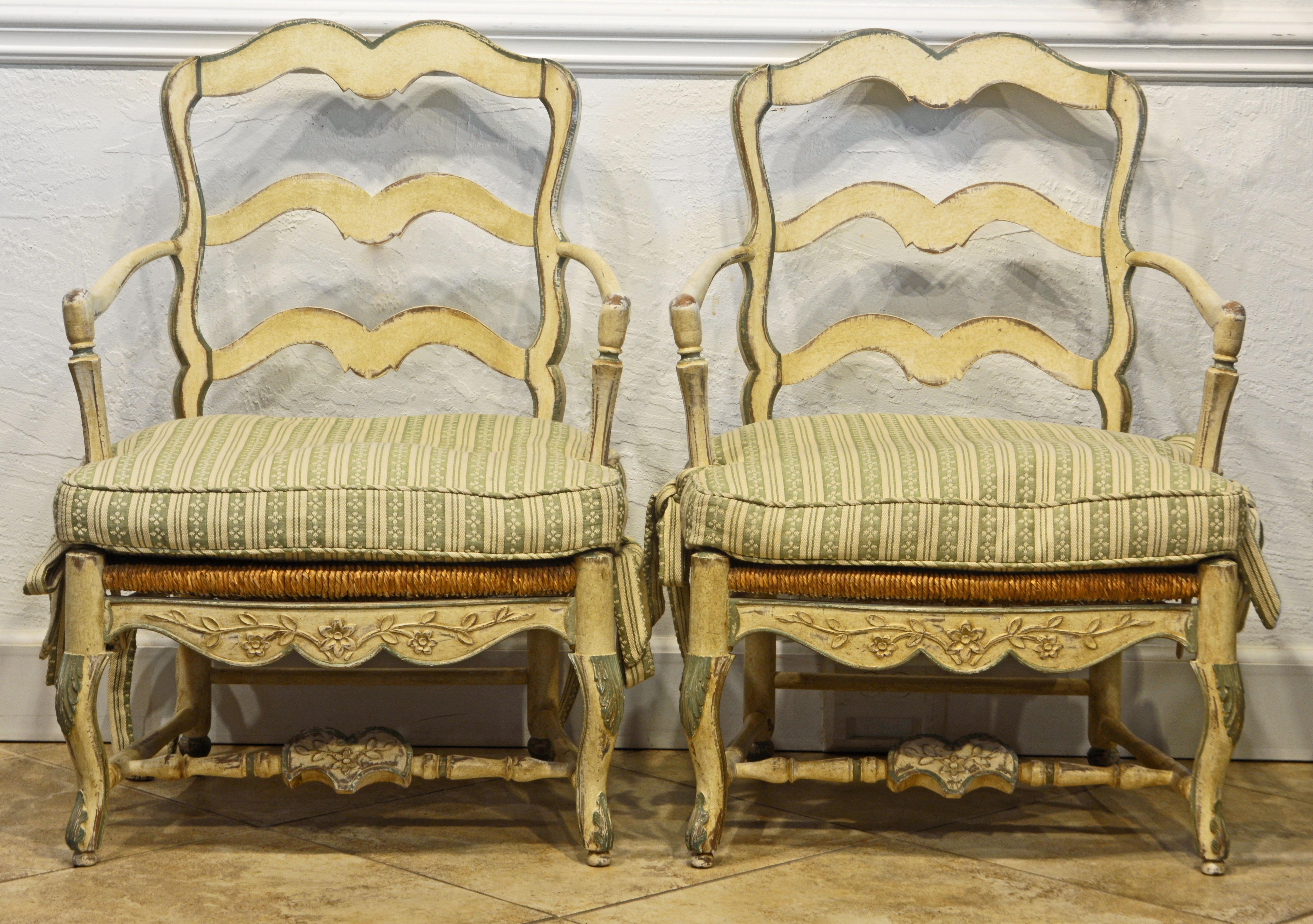 These attractive French carved bergere chairs in the Louis XV style of generous proportions feature beautifully hand carved frames painted antique white with pale green accents supporting rush seats in the French Provincial tradition. The surfaces