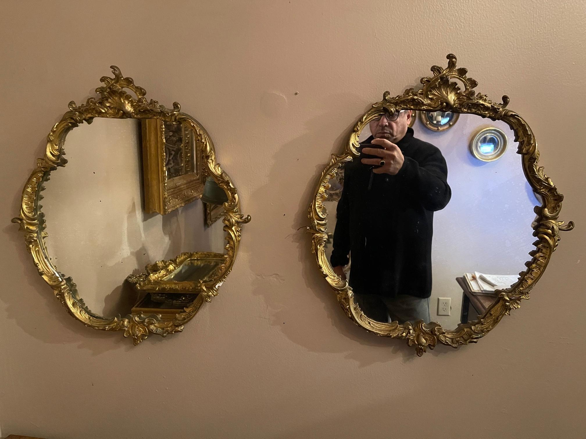 Pair of French Louis XV style carved & gilded rounded mirrors, 19th century.
