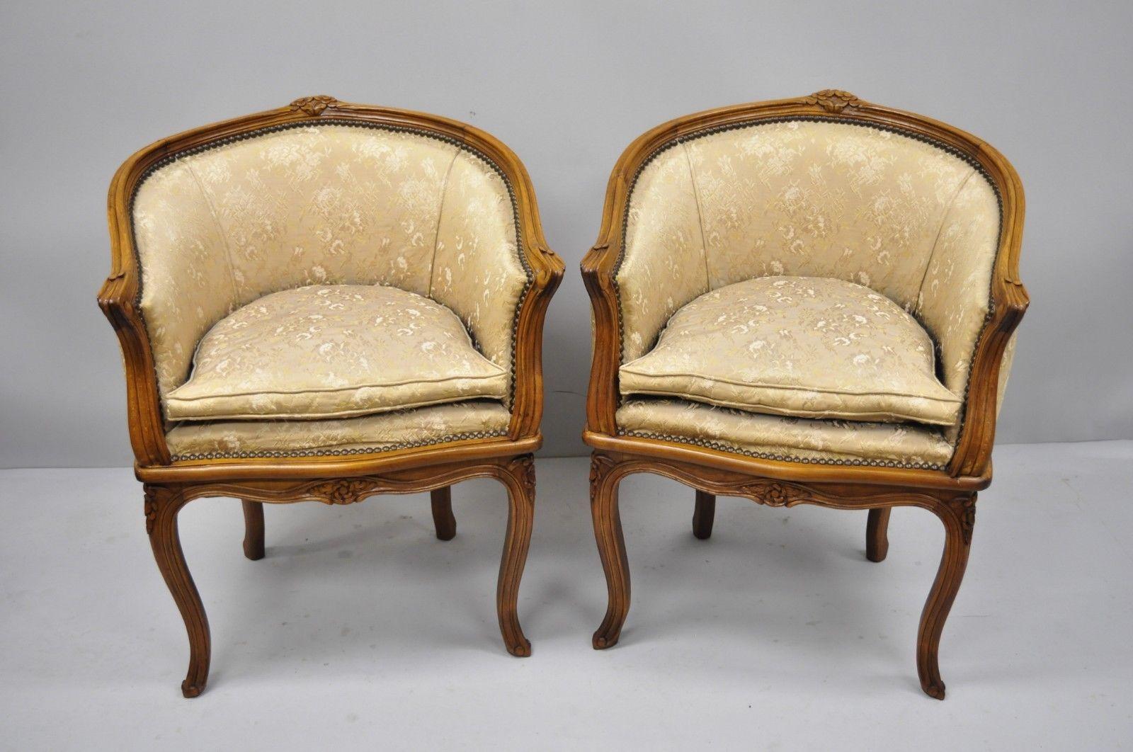 Pair of French Louis XV Style carved walnut barrel back boudoir chairs. Item features shapely barrel backs, pillow cushions, solid walnut construction, finely carved details, and cabriole legs; great style and form, circa early 20th century.