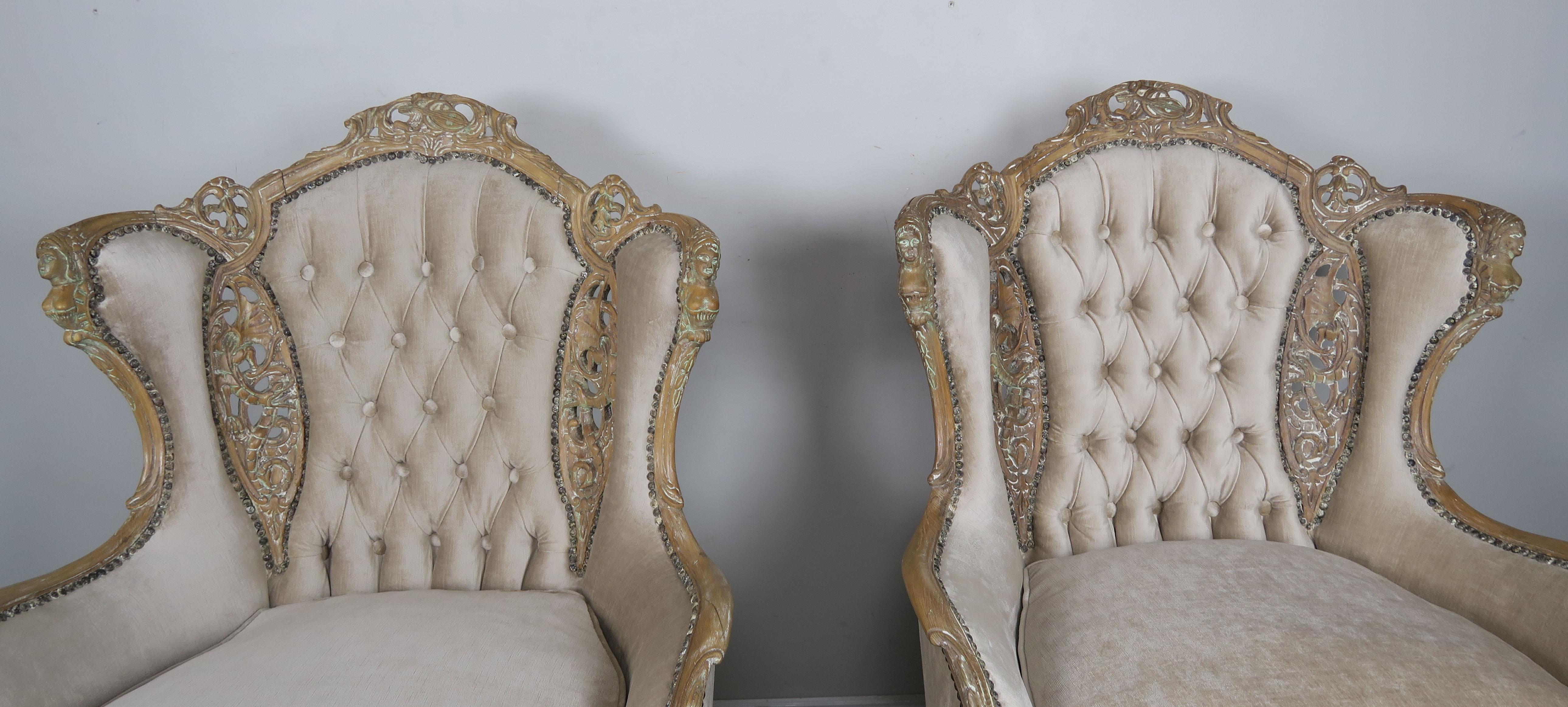 Pair of French Louis XV style cream velvet upholstered bergeres. The back is beautifully tufted and the upholstery is finished with antique brass colored nailhead trim detail. The chairs stand on four cabriole shaped legs with ram's head feet.