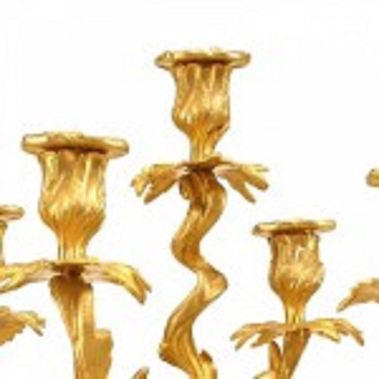 Paire de candélabres français de style Louis XV (19e-20e siècle) à cinq lumières en bronze doré avec des détails feuillagés.
     
