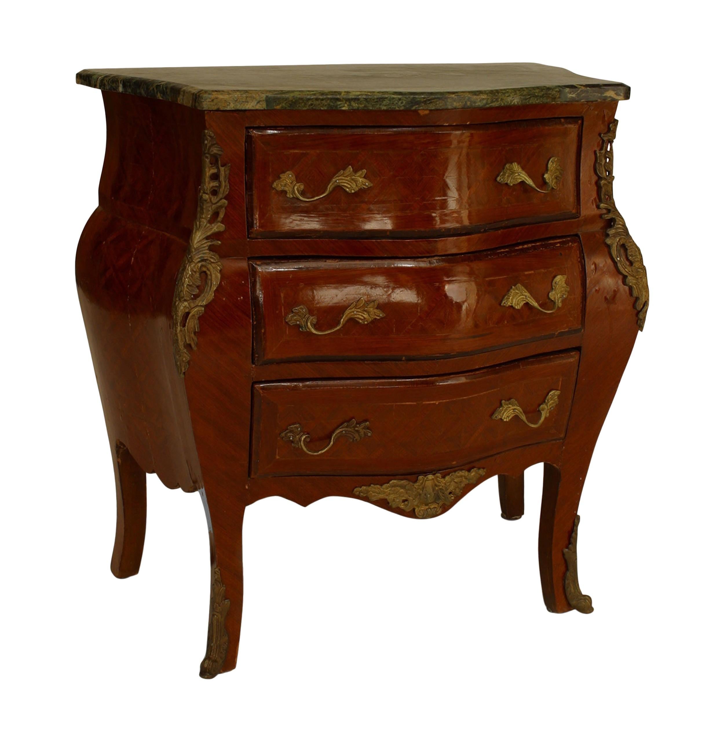 Coppia di comodini in stile Luigi XV (19/20° secolo), in legno di frutto a forma di bombe, con tre cassetti, finiture in bronzo e piano in marmo verde sagomato. (PREZZO A COPPIA)

Condizioni antiche, mostra la sua età.