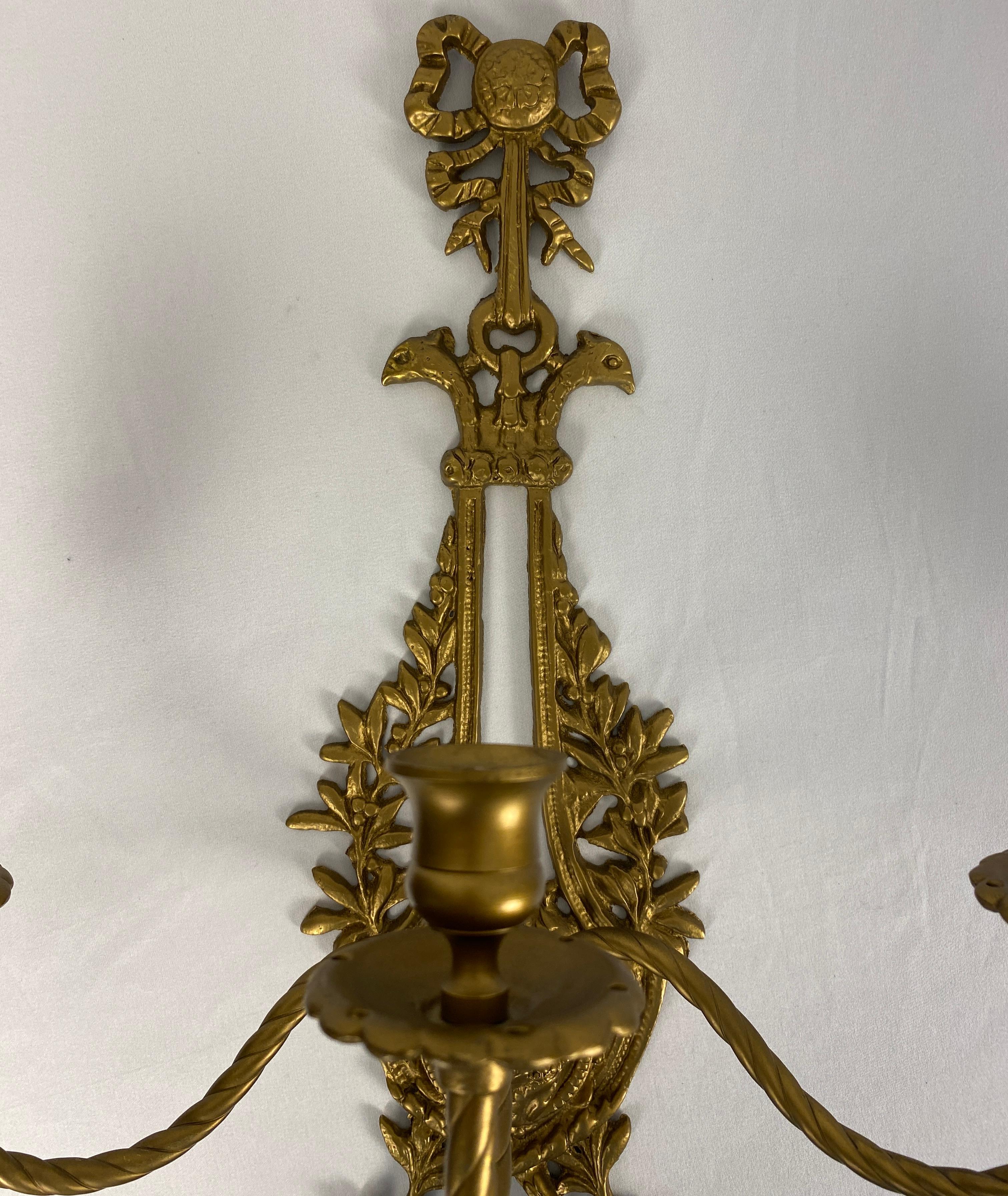 Pair of French Louis XV Rococo style gilded bronze double arm wall sconces, in very good antique condition. Beautiful decorative floral and leaf tiered scrolling arms. 

Very good quality and well cast.

These pair of French Louis XV bronze double