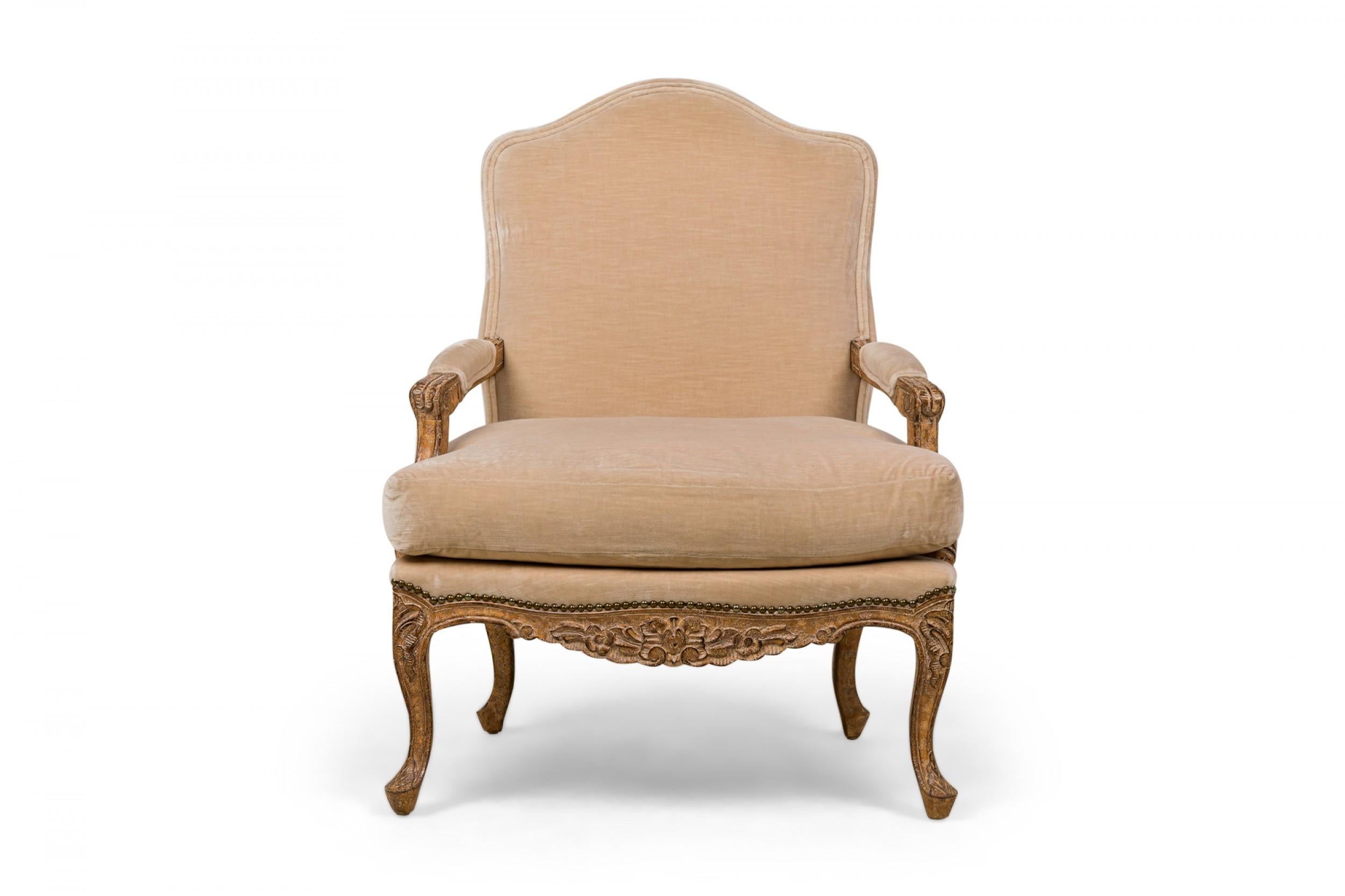 PAIRE de fauteuils de style Louis XV (1ère moitié du 20ème siècle) à haut dossier en forme, avec des cadres sculptés, avec un poisson antique en détresse, des dossiers, des sièges et des coussins d'accoudoirs tapissés de velours beige, et des