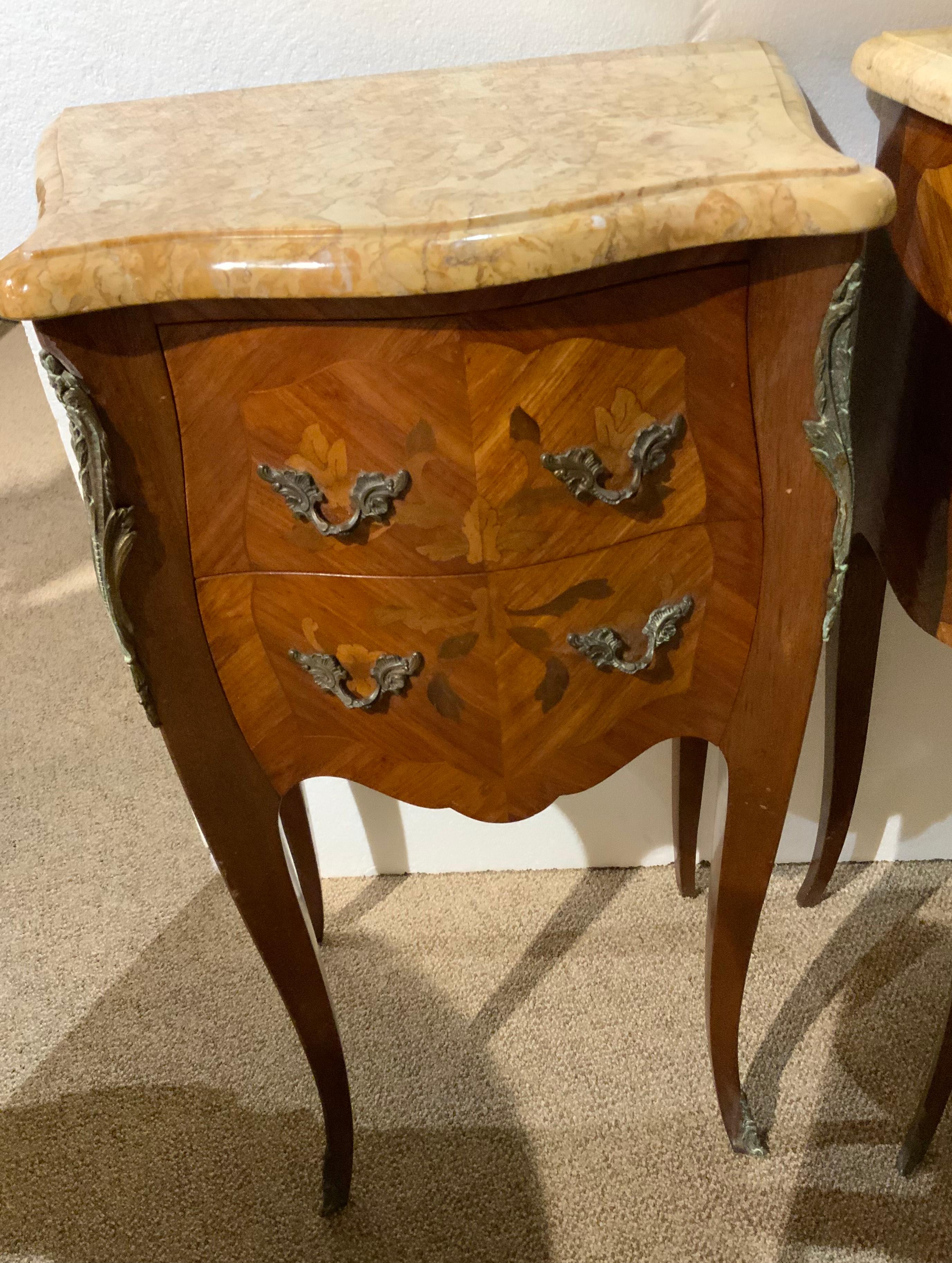 This pair of night stands have original and exceptional finish work.
They have a foliate inlay made of exotic woods. The marble tops
Are in a light gold hue and have no breaks or chips. The legs are
Gracefully curved in the Louis XV style and end