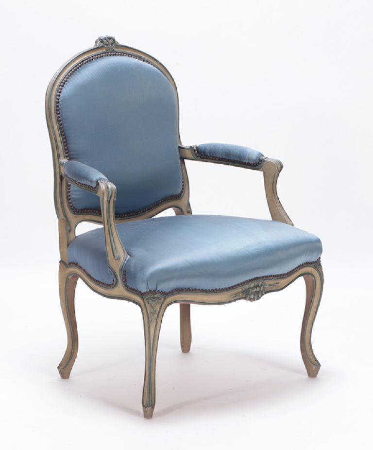 A pair of French Louis XV style open armchairs having painted and carved frames done in a powder blue upholstery circa 1920.