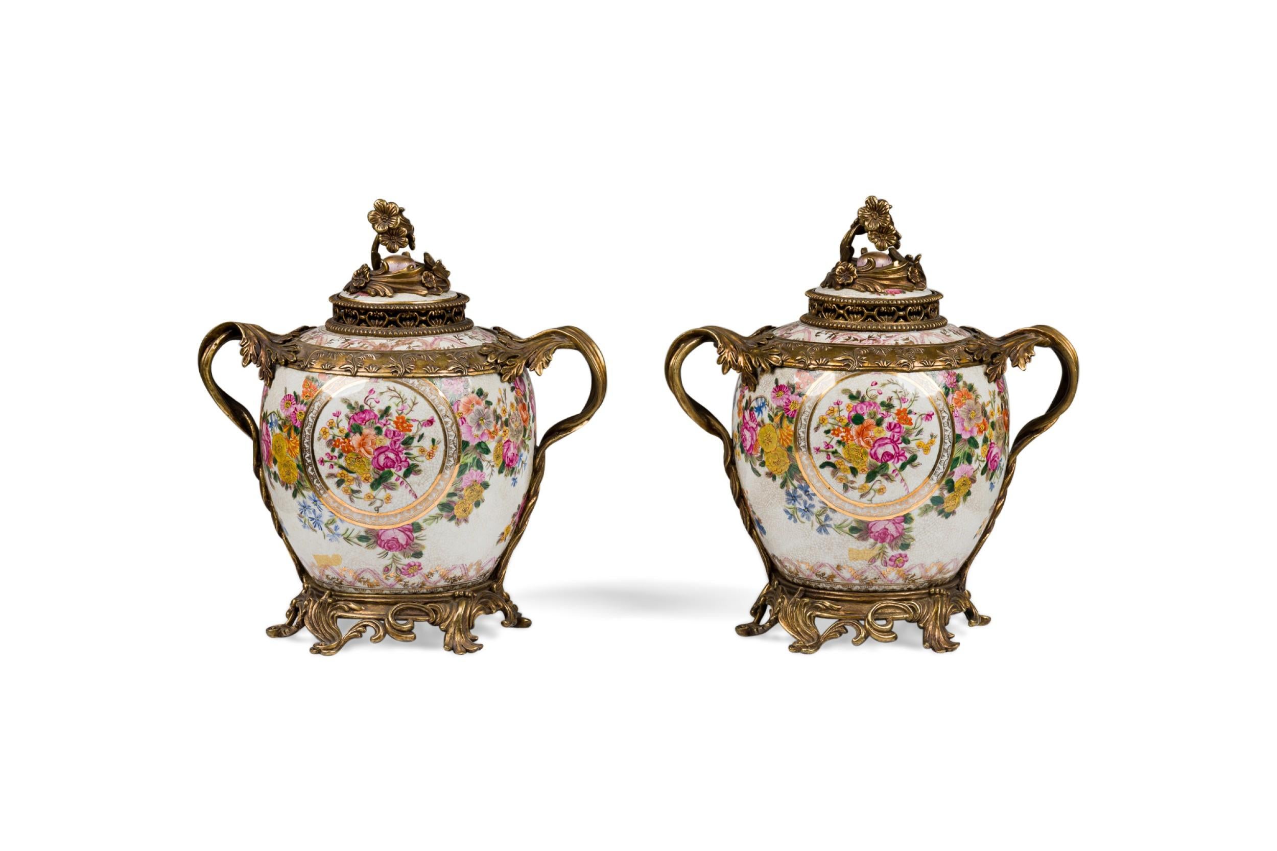 Pärchen französischer Porzellanurnen im Louis XV-Stil (20. Jahrhundert) mit Blumendekoration, montiert auf einem oppulenten Sockel aus vergoldeter Bronze mit verzierten Griffen und einem Deckel (PREIS PRO PÄRCHEN)