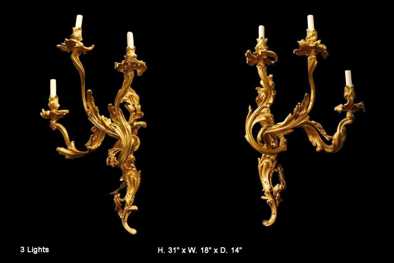 Fabulous opposing pair of French 19 century Louis XV style ormolu three light sconces. 
Each twisted-form sconce is supported by an acanthus inspired central shaft, issuing three scrolling foliate motif arms with conforming foliate dishpans and