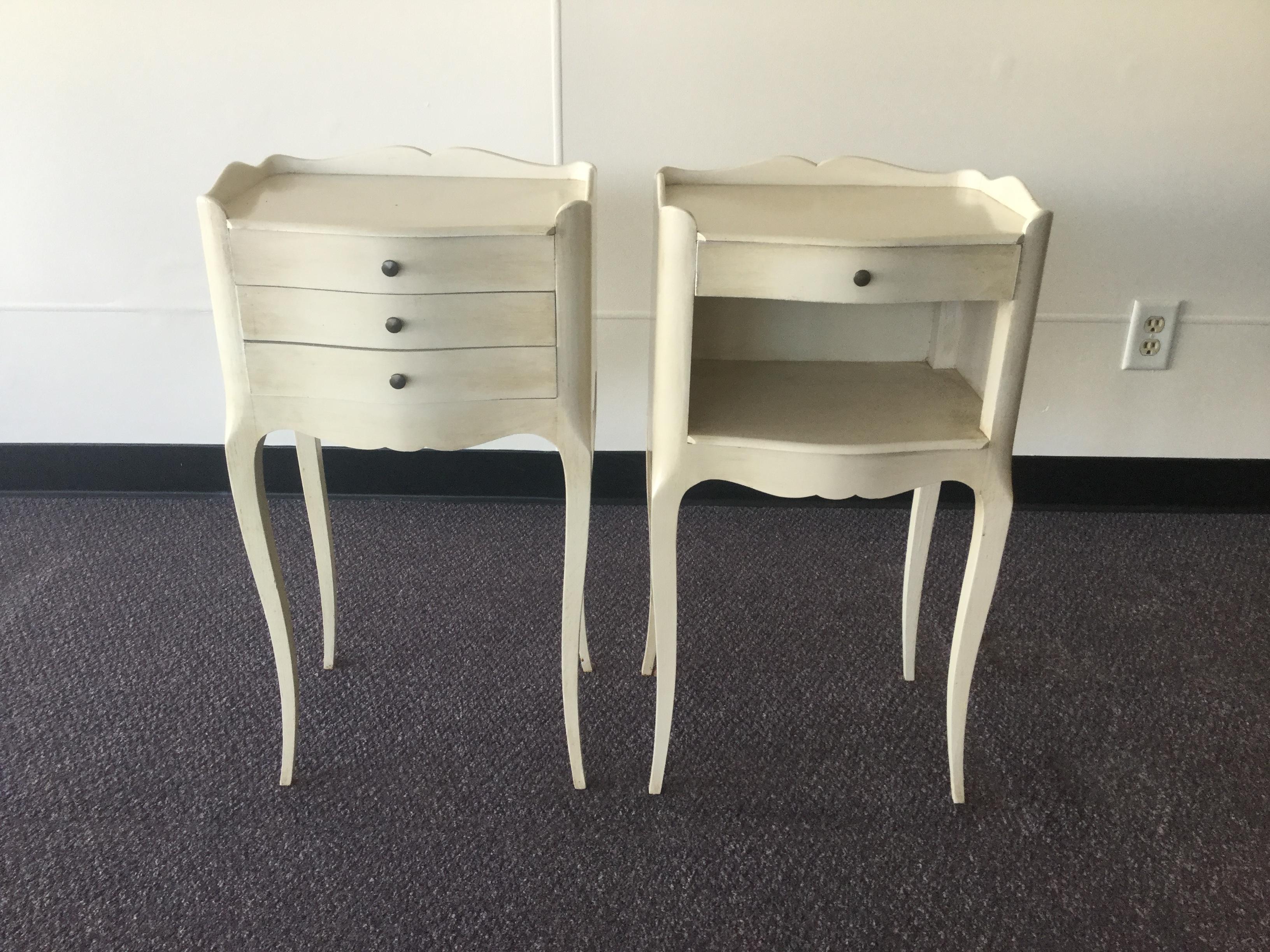 Pair of hand painted vintage French side-tables from the Brittany region of France. Made of cherrywood, these small tables are painted off-white and feature antique brass hardware. One table has three drawers and the 2nd features one drawer and an