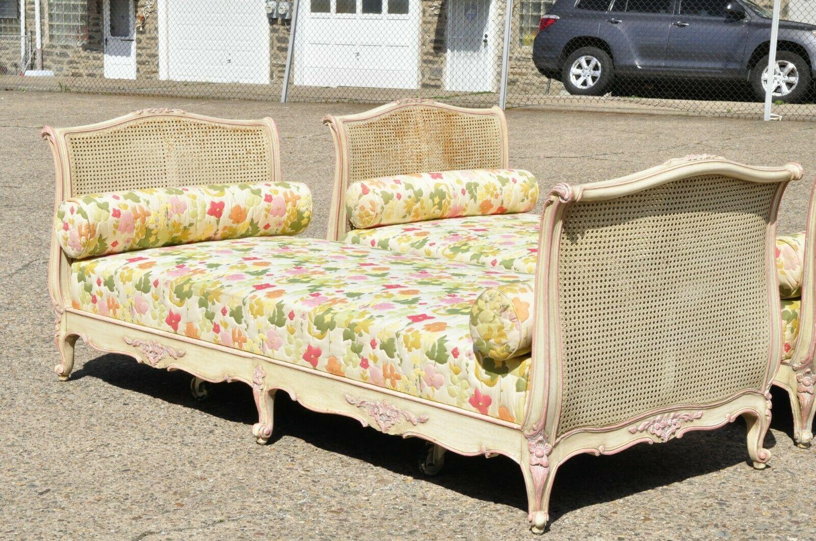 Pair of antique French Louis XV style pink and cream painted carved wood & cane daybeds. Item features double cane foot and headboards, pink and cream painted finish, solid wood frame, cabriole legs, quality craftsmanship, great style and form,