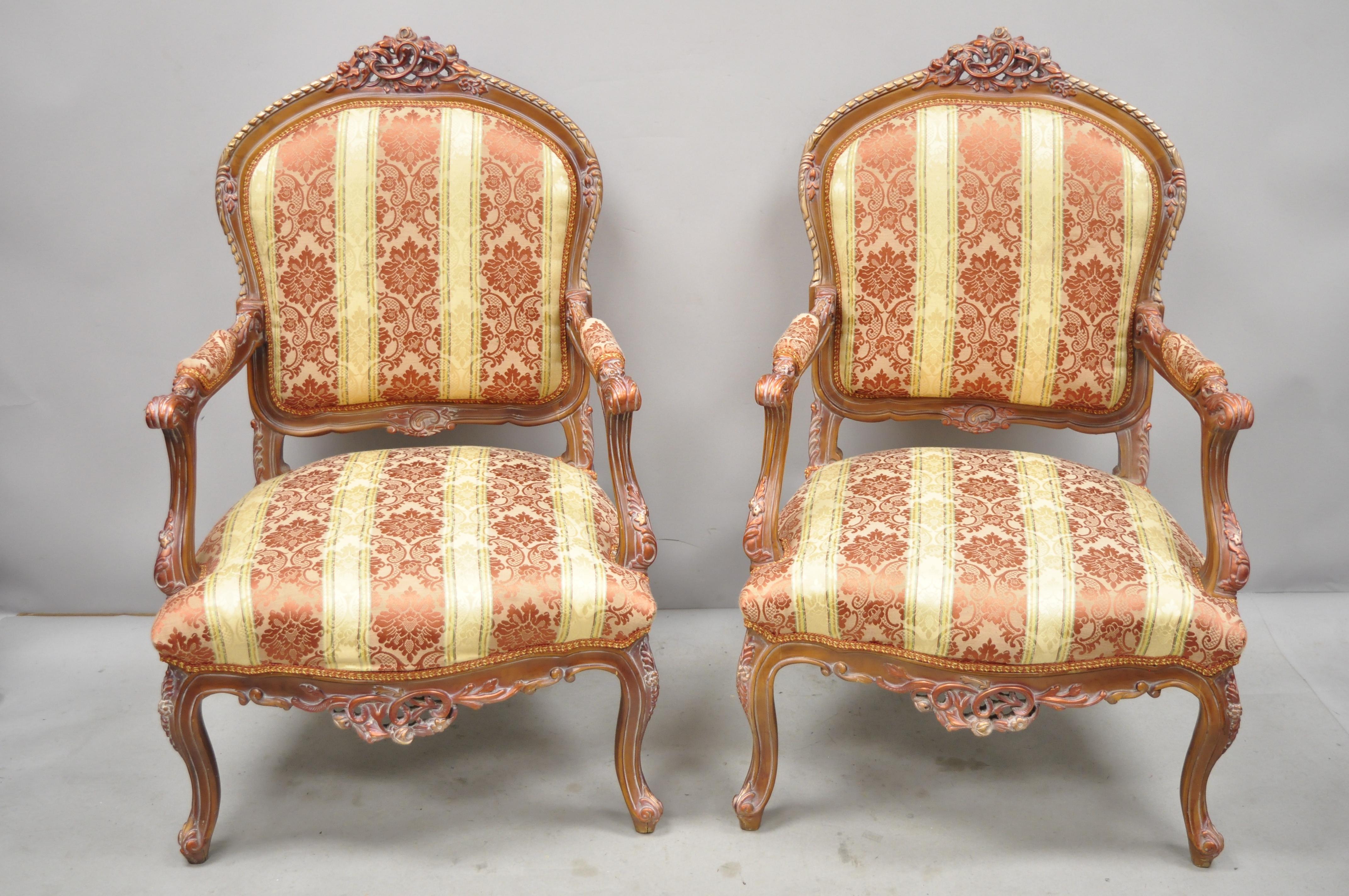 Pair of French Louis XV style repro pink and golf bergere lounge armchairs. Set includes pink and gold upholstery, solid wood frame, upholstered armrests, distressed finish, nicely carved details, cabriole legs, great style and form, circa late