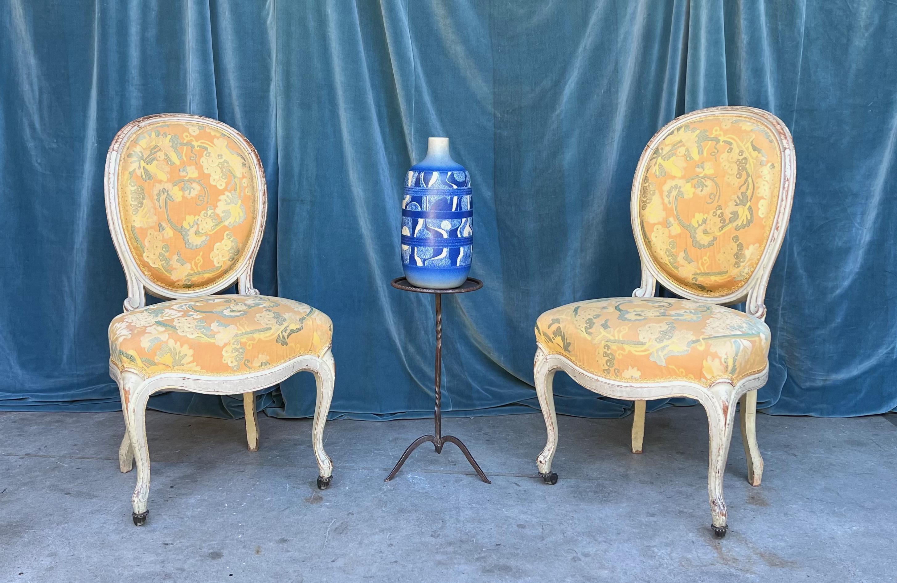 A beautiful pair of Louis XV style side chairs in yellow patterned fabric with white painted frames with traces of gilt. This stunning pair of Louis XV style side chairs will add a touch of elegance and sophistication to any room. The yellow