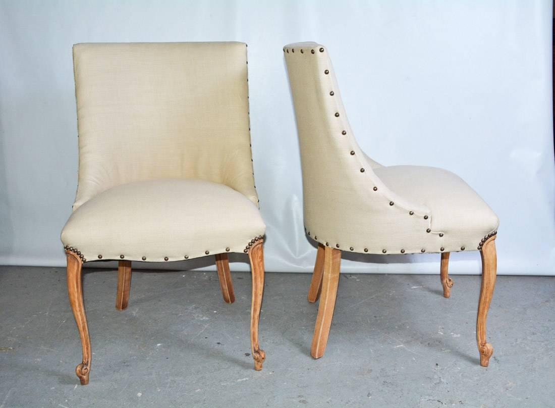 Elegant, sleek and handsome pair of 1940s slipper side chairs newly upholstered in white linen with nailhead finishing. Louis XV style pickled front legs, curved and shaped back with sloping cut-away arms. Great profile and comfort.

Search terms: