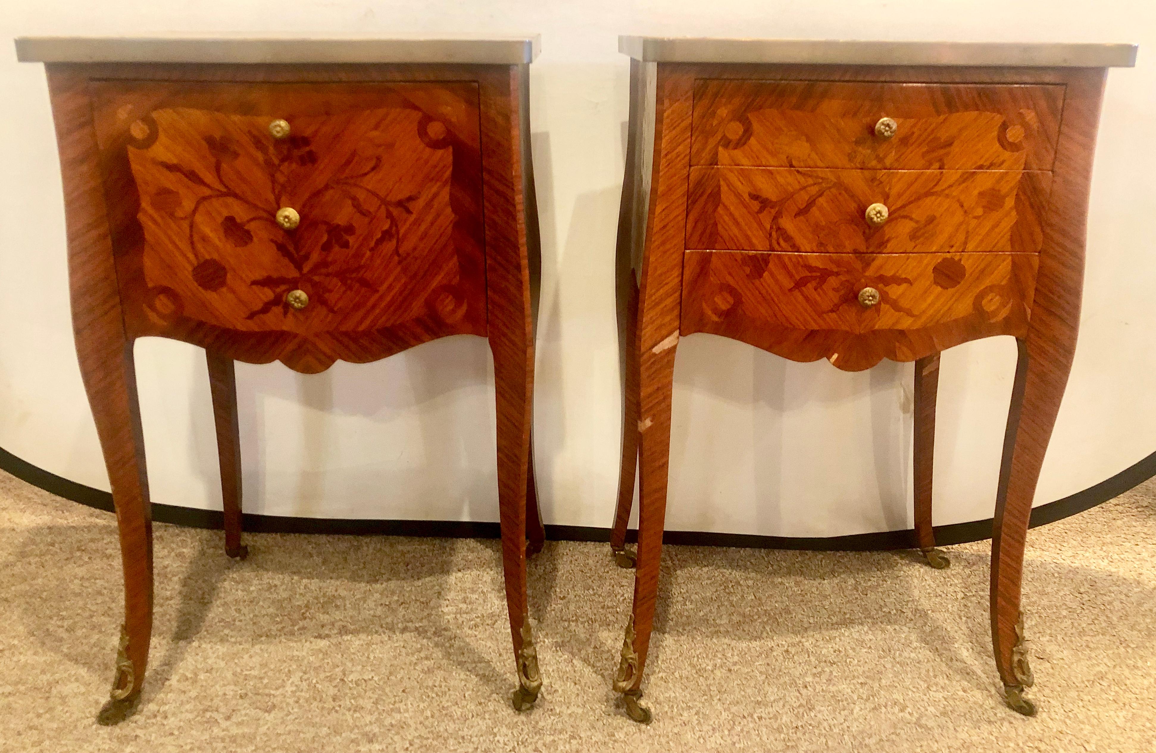 Pair of 1920s French Louis XV style stands, end tables, side tables or night tables one having three drawers the other with a drop front door each having floral inlays supporting bronze galleried marble tops on casters.
Lia.