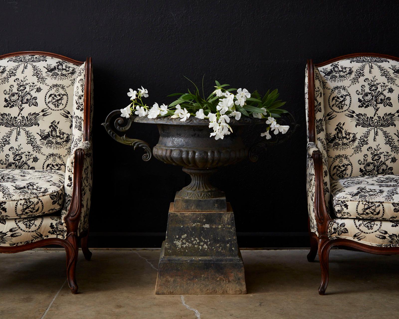 Stunning pair of 19th century French wing chairs featuring a dramatic black and white toile de jouy upholstery. Made in the Classic French Louis XV taste with carved walnut frames. The chair have large fully developed wings and a molded frame with a
