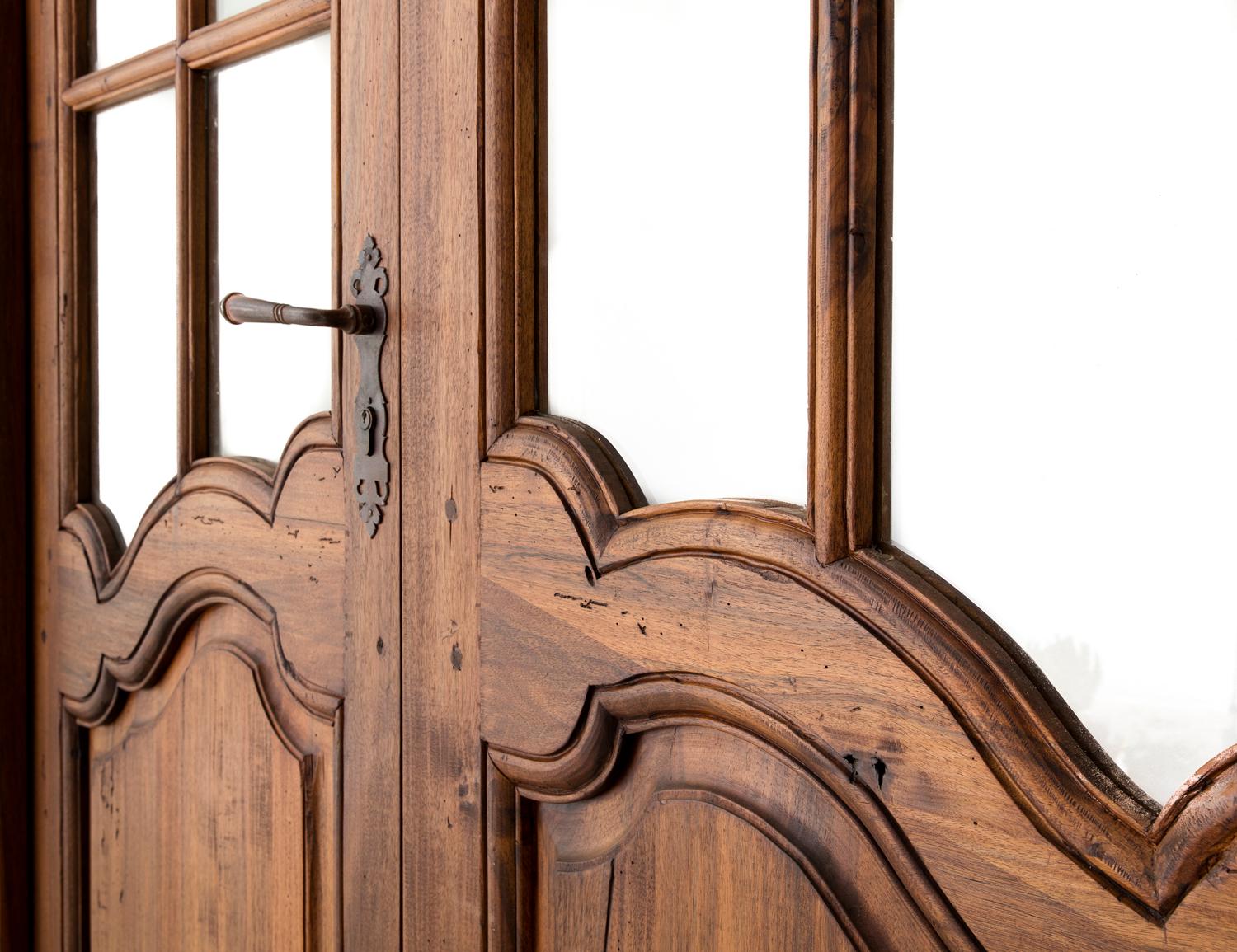 Newly constructed Louis XV style walnut entry doors made by Provençale artisans using traditional methods. This features beautiful paned glass and iron hardware typical of the Provençale style. Keys included. The left door is 28 inches wide and the