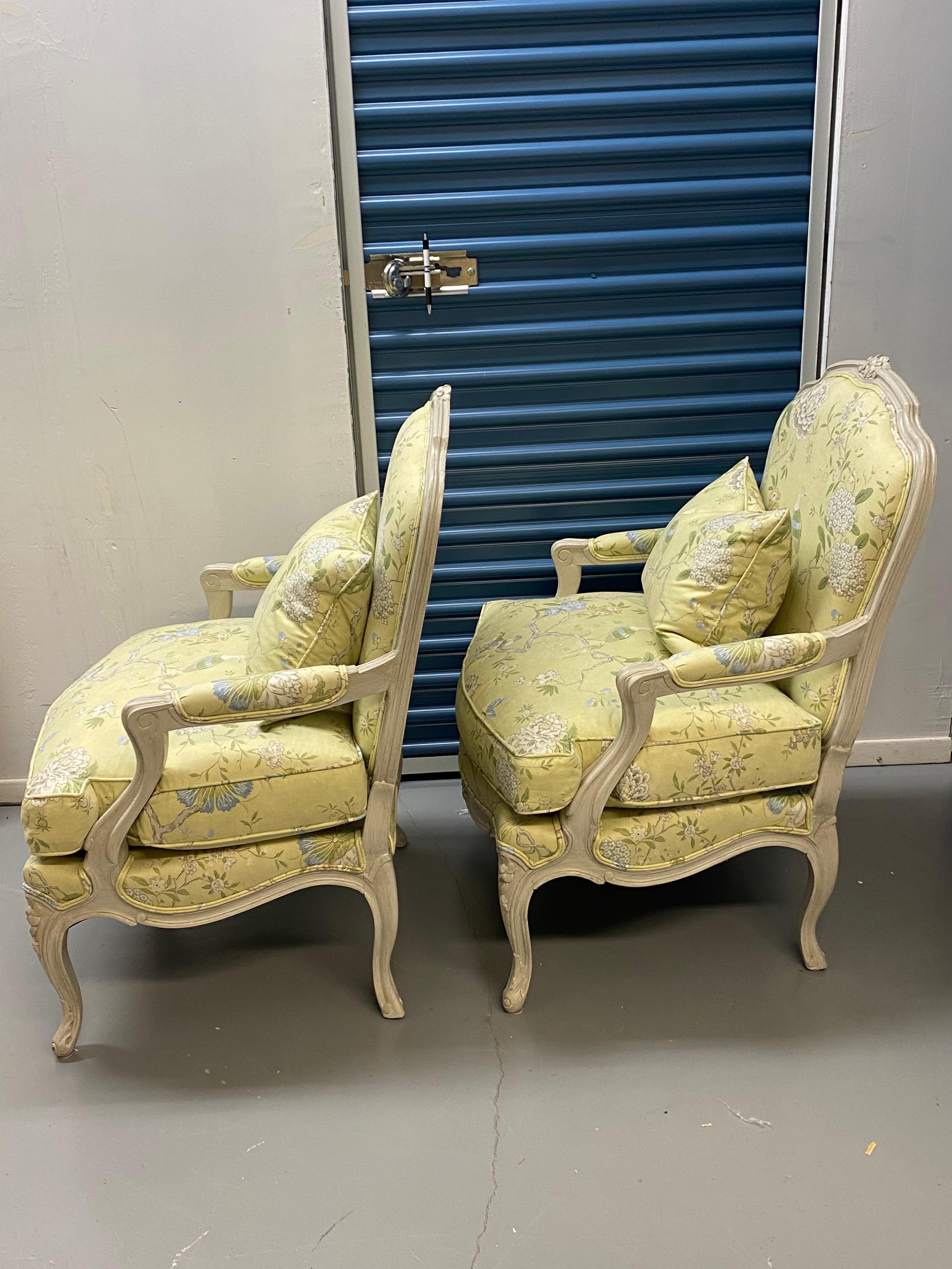 Pair of 20th Century Louis XV Style Upholstered Armchairs
A pair of French Louis XV style grey-white painted wood frame armchairs upholstered in a bright green-yellow cotton chinoiserie fabric. 
Some light wear on finish on legs. Upholstery in good