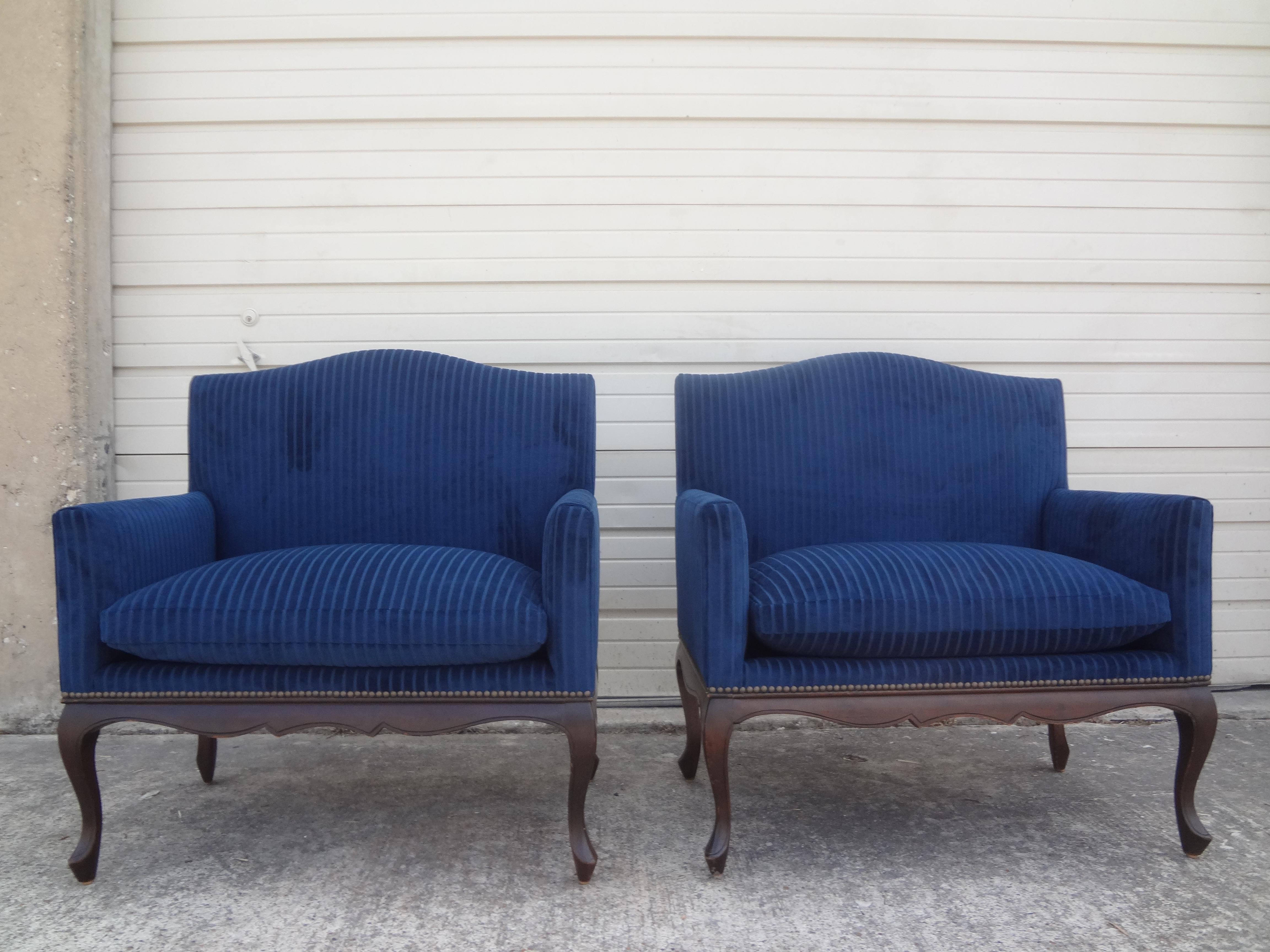 Pair of 19th century French Louis XV-XVI style walnut Marquise. Marquises are oversized bergeres, loveseats or large chairs. This stunning pair of matching French Louis XVI style walnut marquises have been professionally upholstered in navy blue