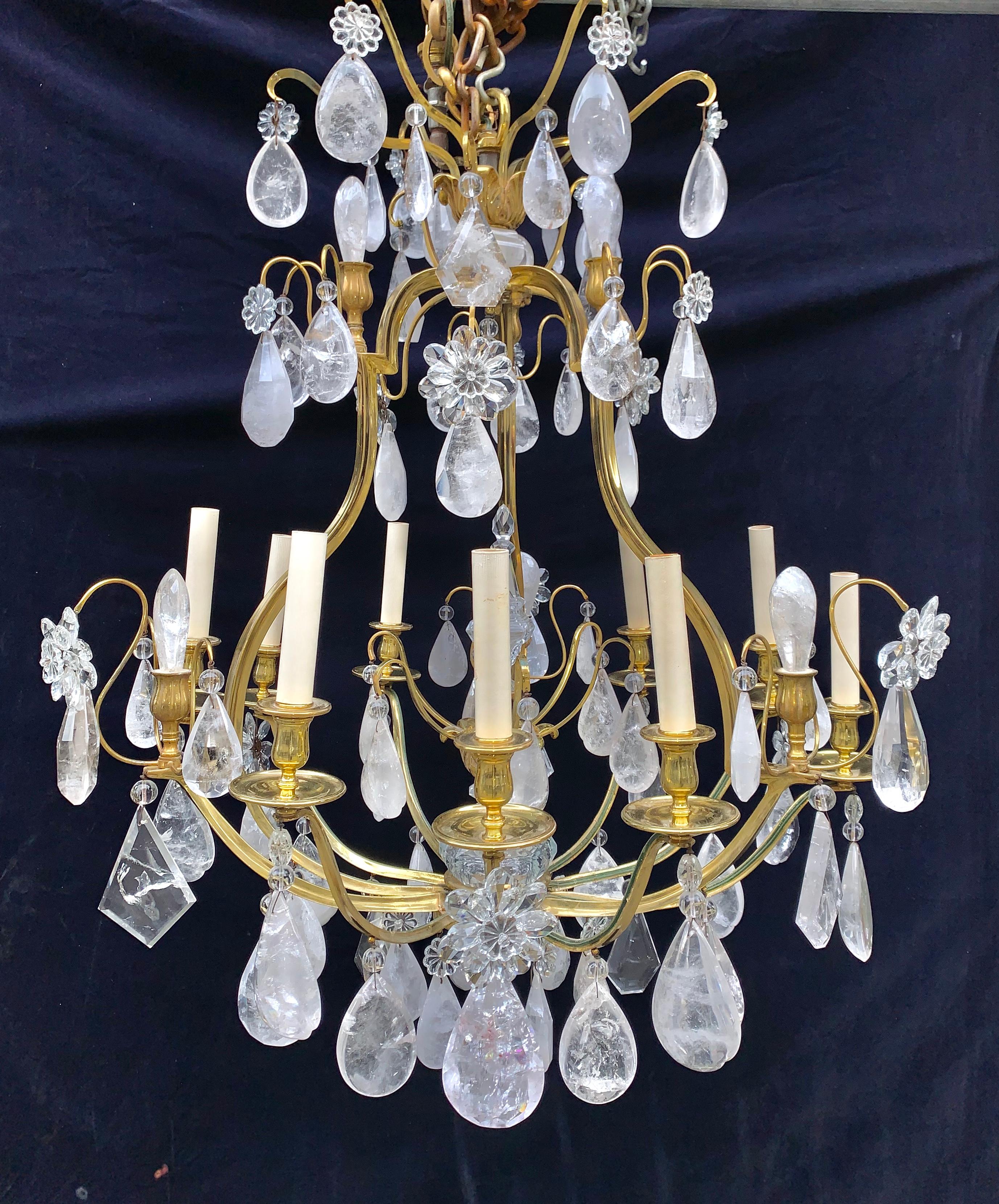 A pair of large French Louis XVI Baguès style gilt bronze and cut rock crystal multi light cage form chandeliers of fine quality embellished with large cut rock crystals prisms and flowers finally adorned with cut rock crystal balls.