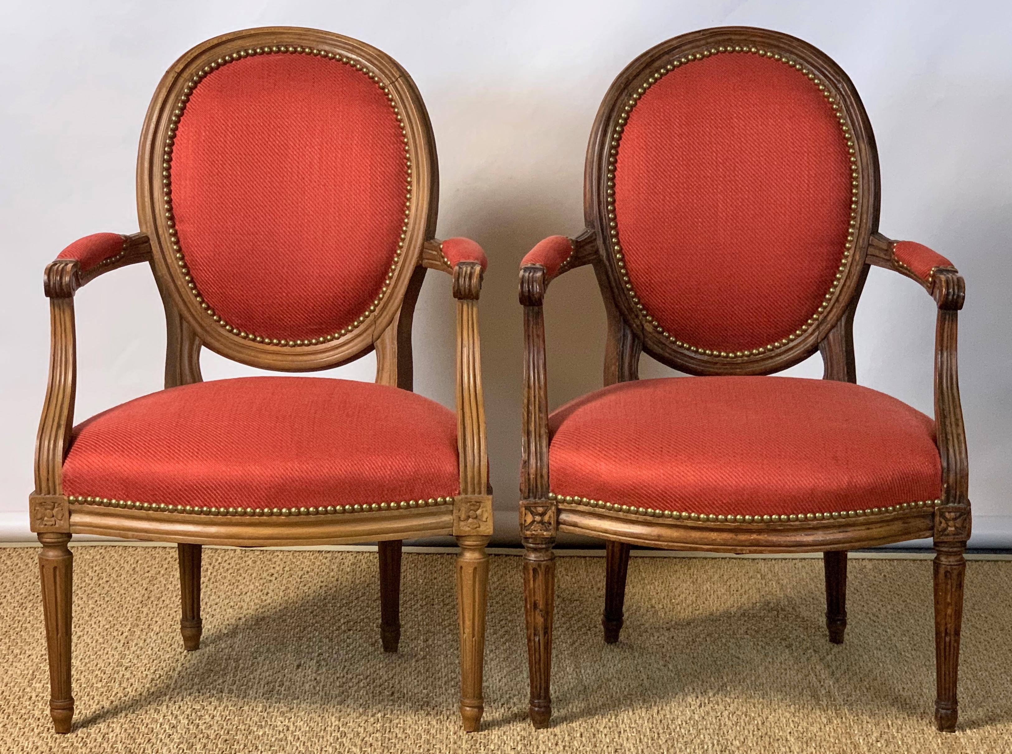 A near pair of French Louis XVI beechwood fauteuils, one dating from the late 18th century, the other made to match some time in the 20th century. Both have recently been upholstered in a red linen blend fabric with contrasting backs.