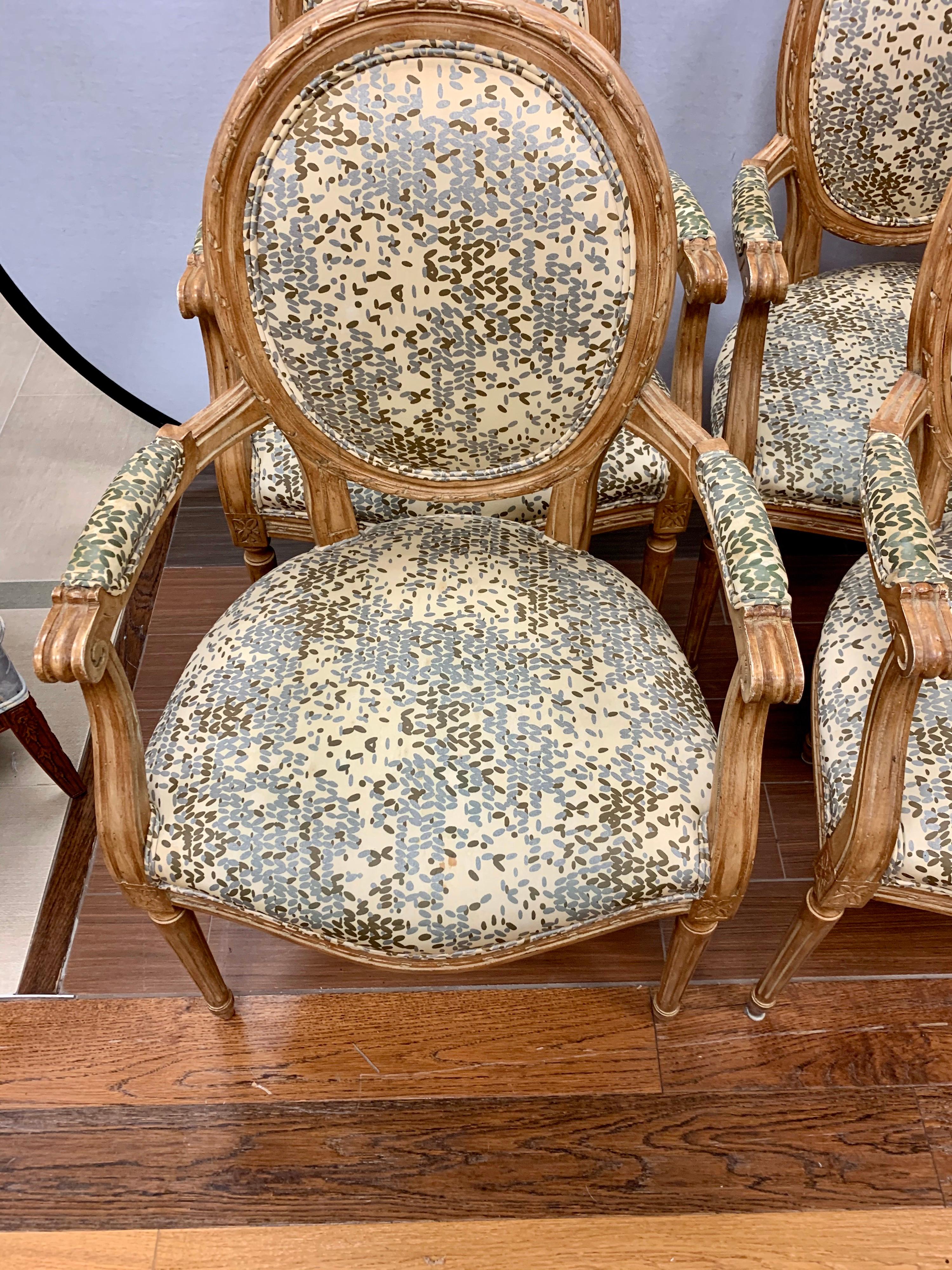 Coveted pair of Louis XVI oval back armchairs with Kravet fabric. The carvings throughout the fruitwood are intricate yet tasteful. The upholstery is at seat, backrest and armrests. All dimensions are below. Both chairs are matching armchairs.