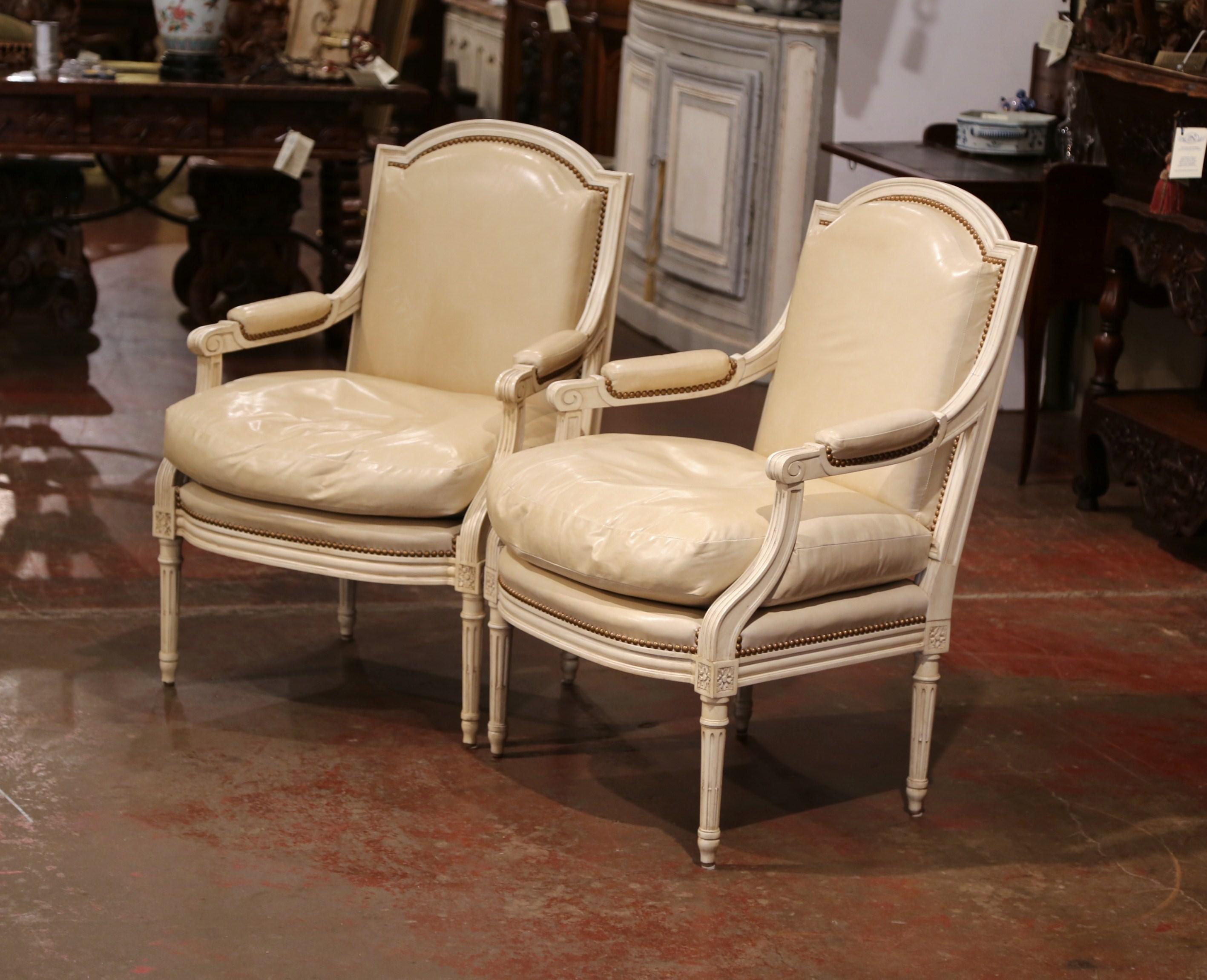 Place this elegant pair of upholstered, versatile fauteuils in your study or library for comfortable yet chic seating. Crafted in France, each armchair reflects the ornate Louis XVI style features hand carved tapered legs, an arched back and padded