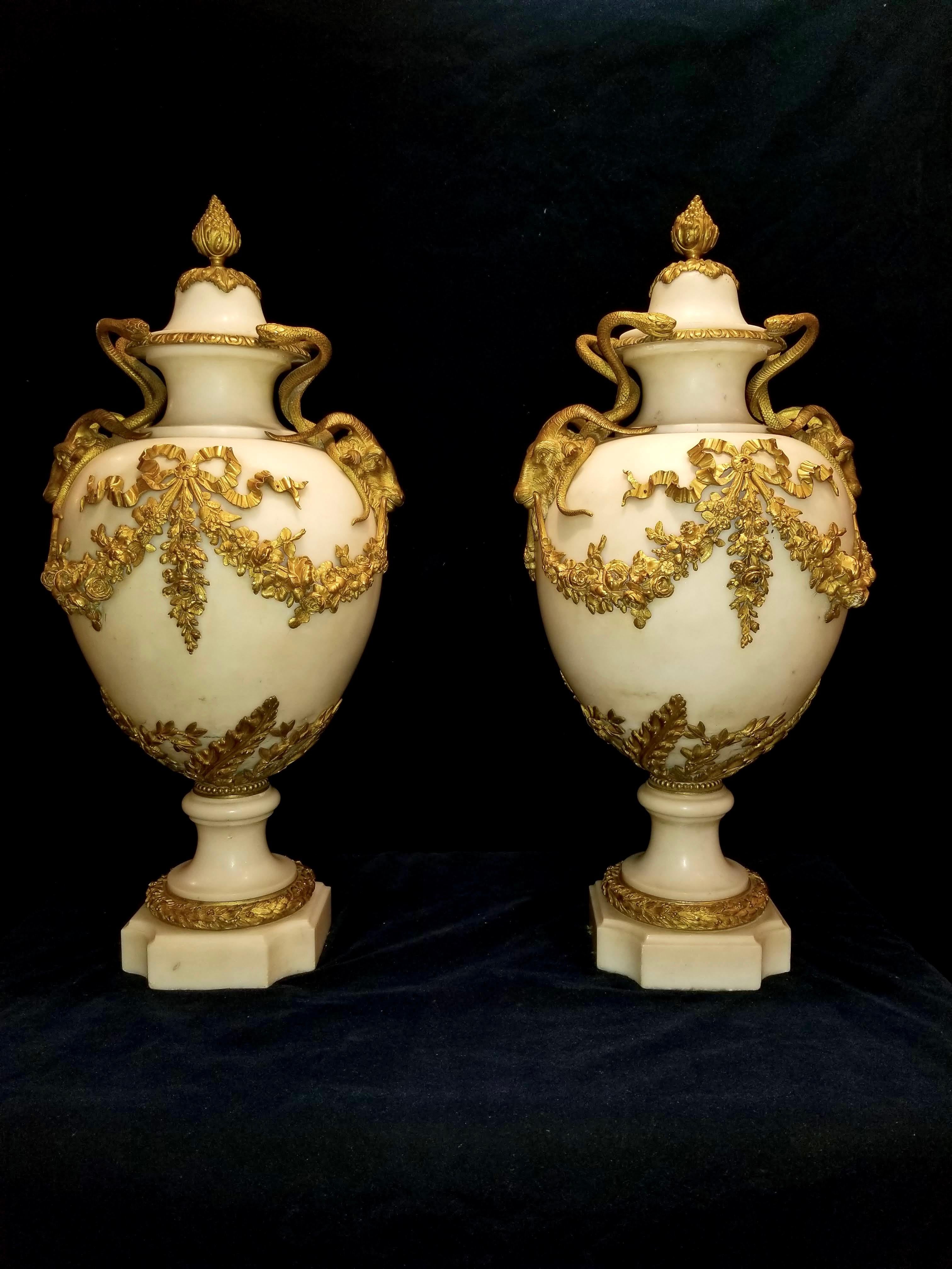 A very fine and monumental pair of antique French Louis XVI doré bronze and white carrara marble covered vases with ram’s heads and serpentine handles, attributed to Henry Dasson. These magnificent vases are made with the highest quality of flawless