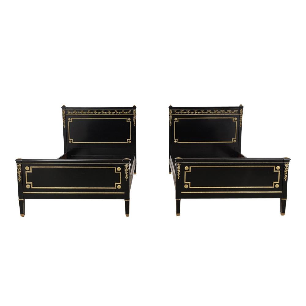 This remarkable pair of 19th century Louis XVI style twin-size beds mahogany frames are been restored and are in good condition. This pair of beds future a professional ebonized lacquer finishing. The beds have a heavily detailed brass moldings and