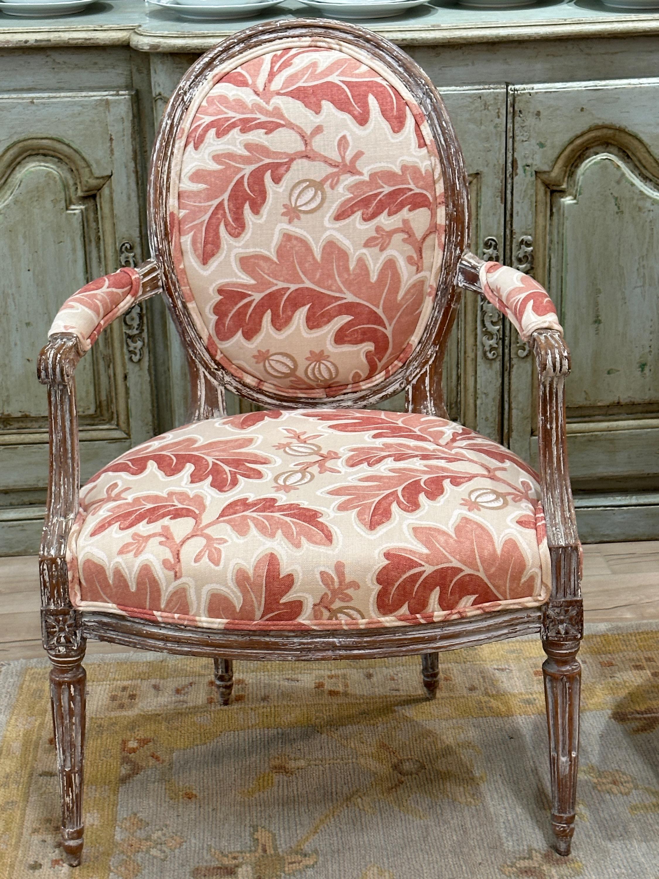 A pair of late 18th c. French fauteuils elegantly carved, retaining old traces of paint over exposed wood, recently upholstered in a pink and cream Colefax & Fowler linen fabric.