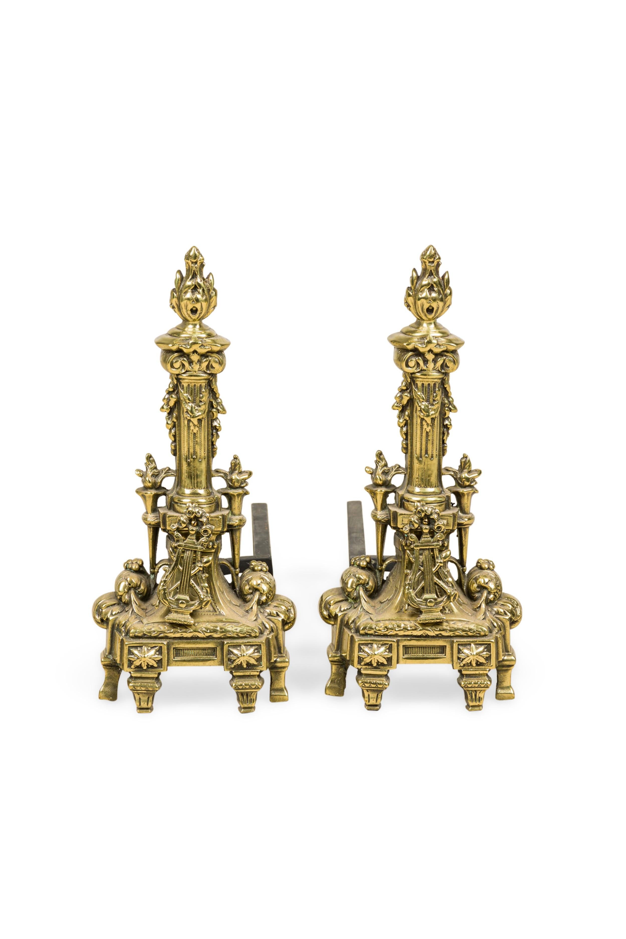 PAIR of French Louis XVI style bronze andirons with a flame top design torch column and a lyre in front