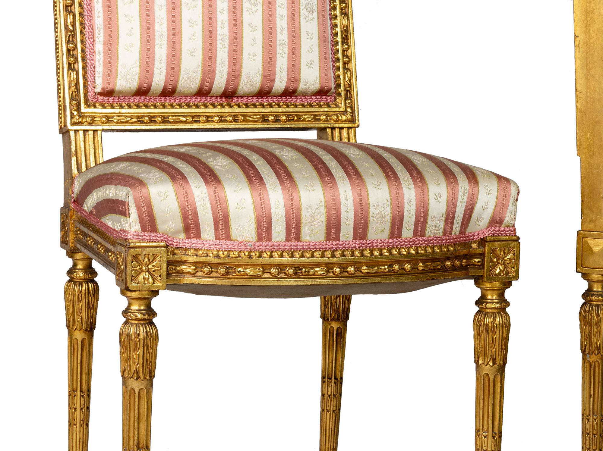 Una raffinata coppia di sedie francesi in stile Luigi XVI con eleganti cornici in legno dorato. 
Le sedie presentano motivi floreali e fogliati finemente intagliati sulla cresta, sulla seduta e sulle gambe, con supporti affusolati torniti e