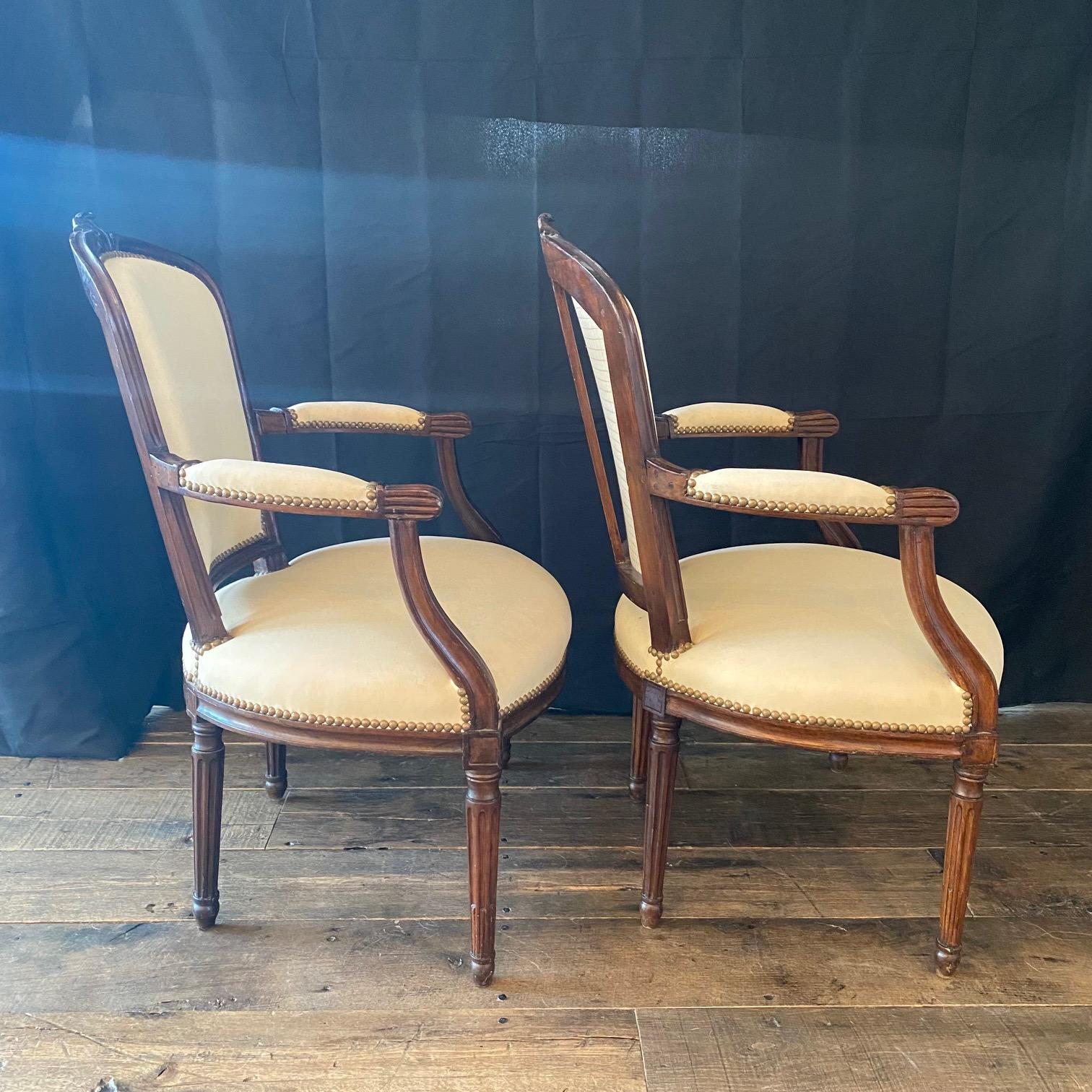 Exquisite Paar des späten neunzehnten Jahrhunderts Französisch Louis XVI-Stil Sessel oder fauteuils, aus massivem Nussbaum, mit wunderschön handgeschnitzten Details, einschließlich der schönen Creme und blass rosa Seide Polsterung, handgeschnitzte